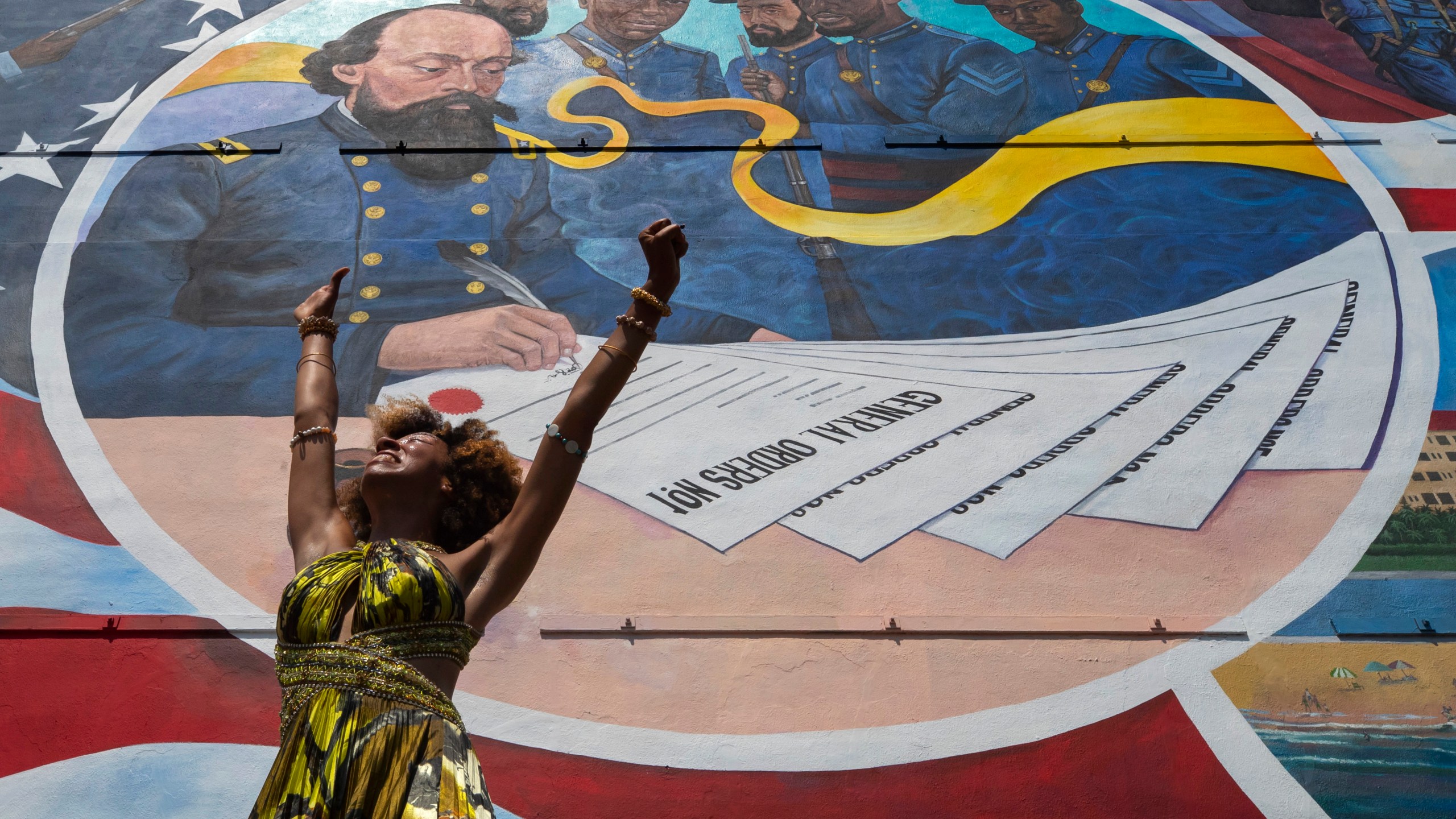 FILE - Dancer Prescylia Mae, of Houston, performs during a dedication ceremony for the massive mural "Absolute Equality" in downtown Galveston, Texas, on June 19, 2021. Communities all over the country will be marking Juneteenth, the day that enslaved Black Americans learned they were free. For generations, the end of one of the darkest chapters in U.S. history has been recognized with joy in the form of parades, street festivals, musical performances or cookouts. Yet, the U.S. government was slow to embrace the occasion. (Stuart Villanueva/The Galveston County Daily News via AP, File)