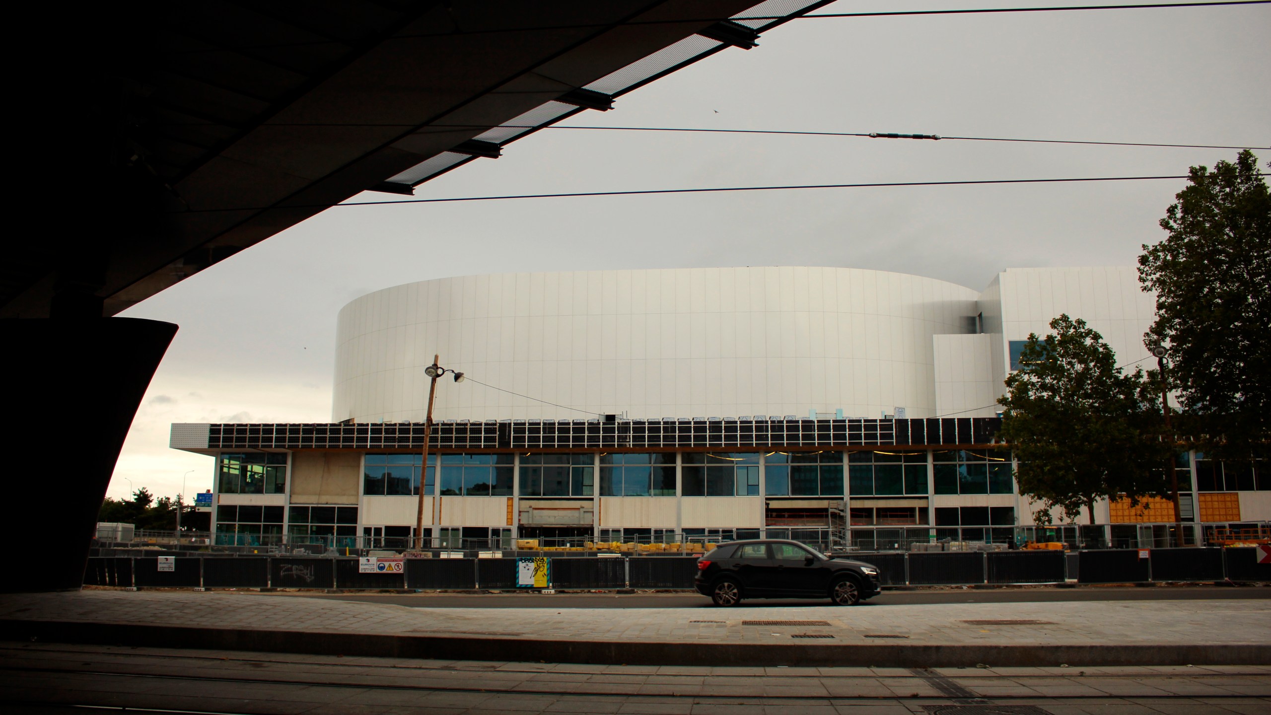 A car drives past the future Olympic venue "Porte de la Chapelle Arena" in Paris, Sunday, July 23, 2023. Paris authorities are trying to clear out crack users from a long-blighted neighborhood near a new venue built for the Paris 2024 Olympics, with mixed effects. (AP Photo/Youcef Bounab)