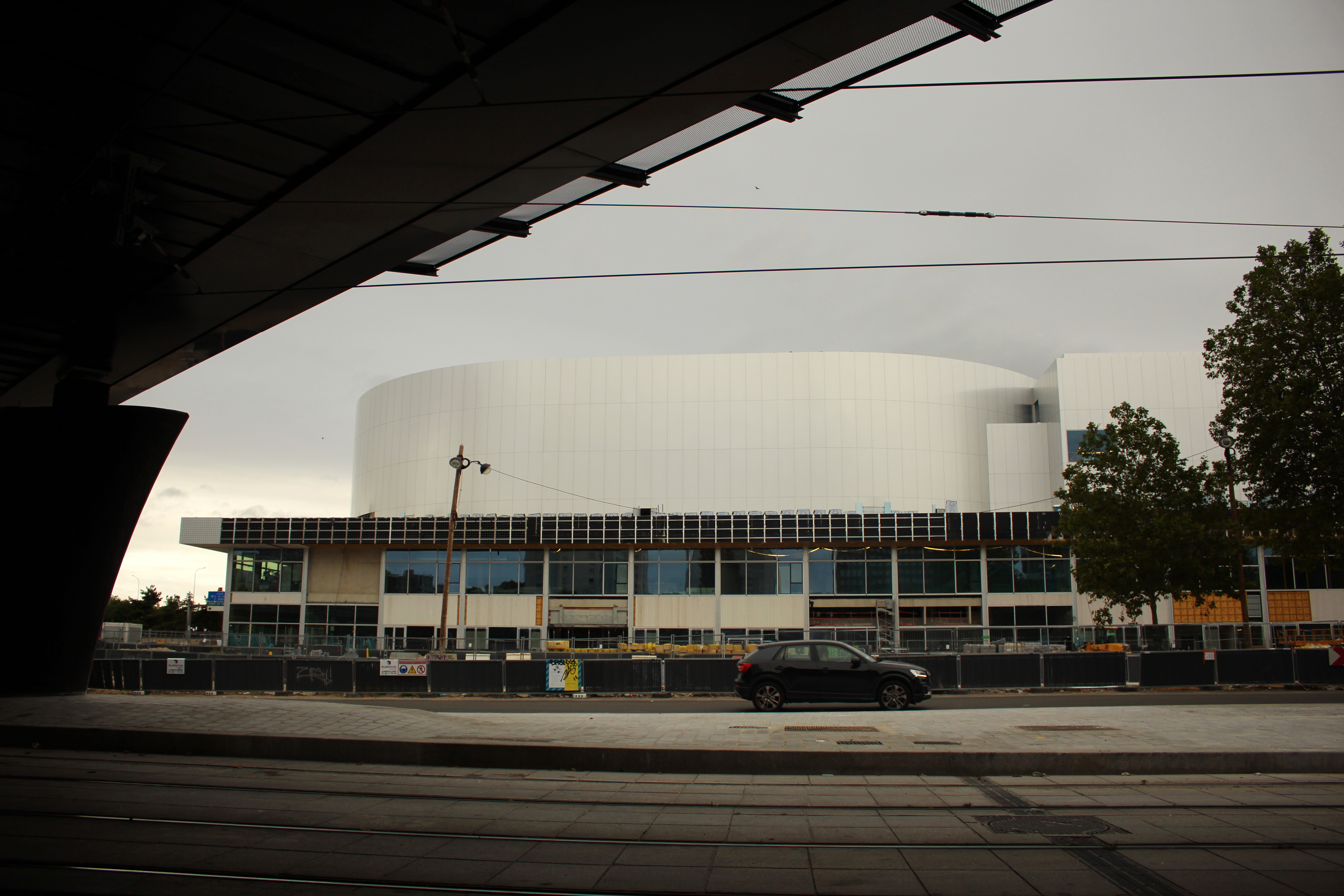 A car drives past the future Olympic venue "Porte de la Chapelle Arena" in Paris, Sunday, July 23, 2023. Paris authorities are trying to clear out crack users from a long-blighted neighborhood near a new venue built for the Paris 2024 Olympics, with mixed effects. (AP Photo/Youcef Bounab)