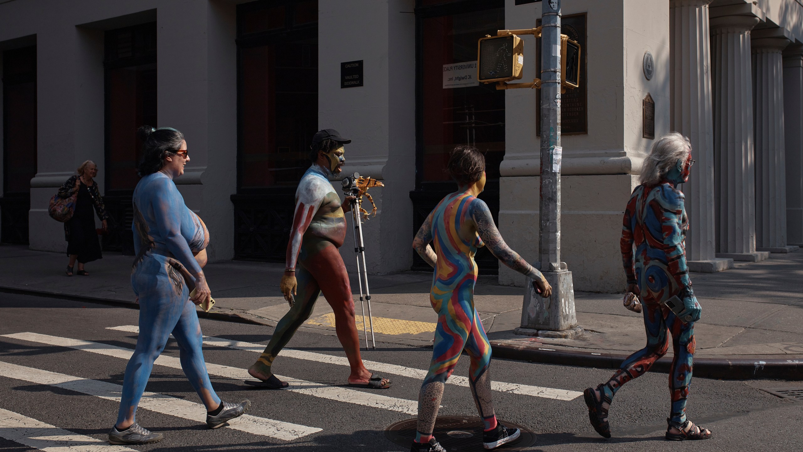 Models painted by an artist cross the street after the Human Connection Arts Annual NYC Bodypainting Day in Union Square Park, Sunday, July 23, 2023, in New York. Sunday’s Bodypainting Day will be the final edition after more than a decade of artists turning nude bodies into works of art. (AP Photo/Andres Kudacki)