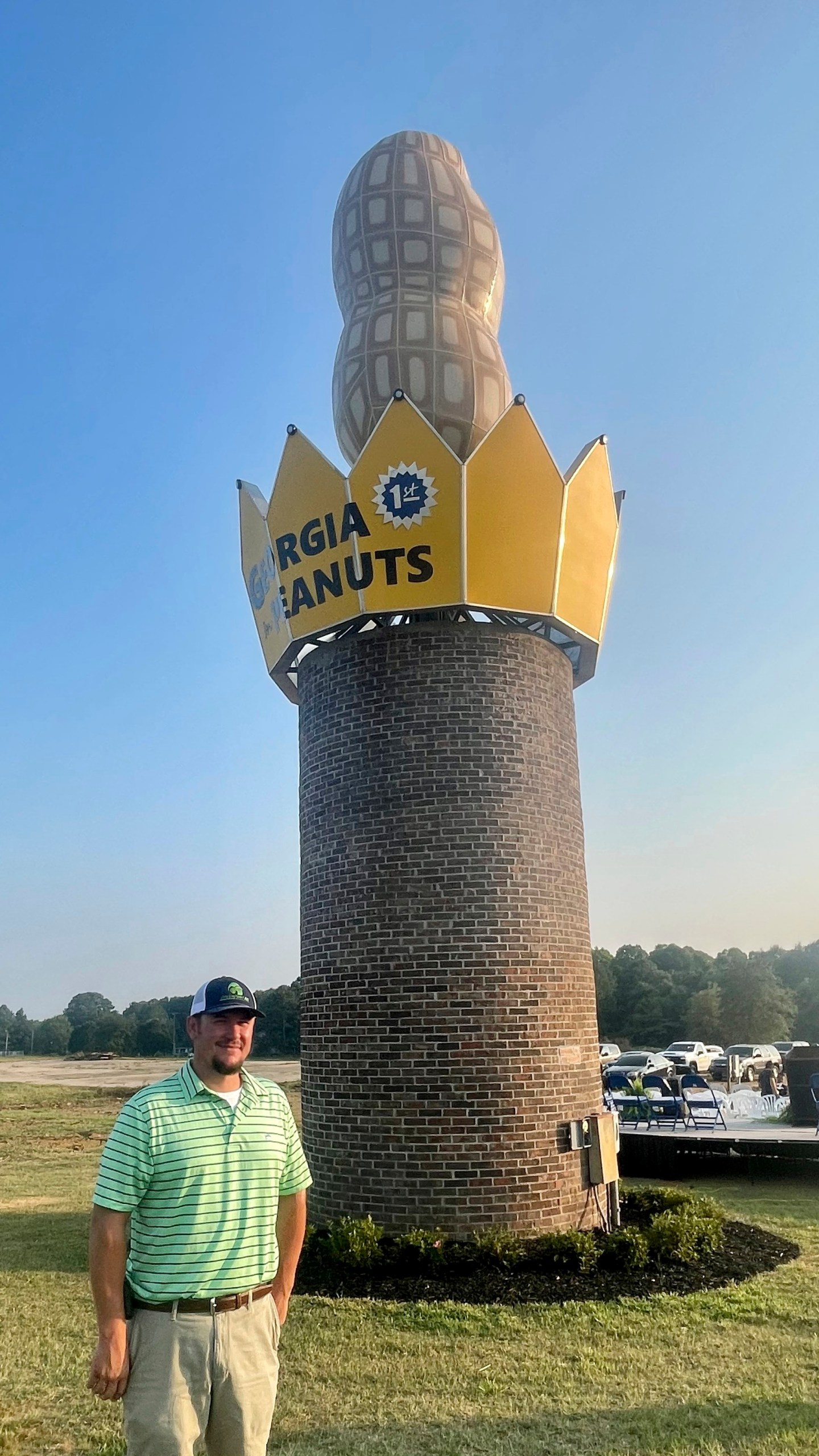 This photo provided by the Georgia Peanut Commission shows Cole Sercer of Sercer Machine & Fabrication, standing beside the Big Peanut that he and his employees designed and built near Interstate 75 in Ashburn, Ga., Thursday, July 20, 2023. The monument replaces a similar peanut that blew down during Hurricane Michael in October 2018. (Joy Crosby/Georgia Peanut Commission via AP)