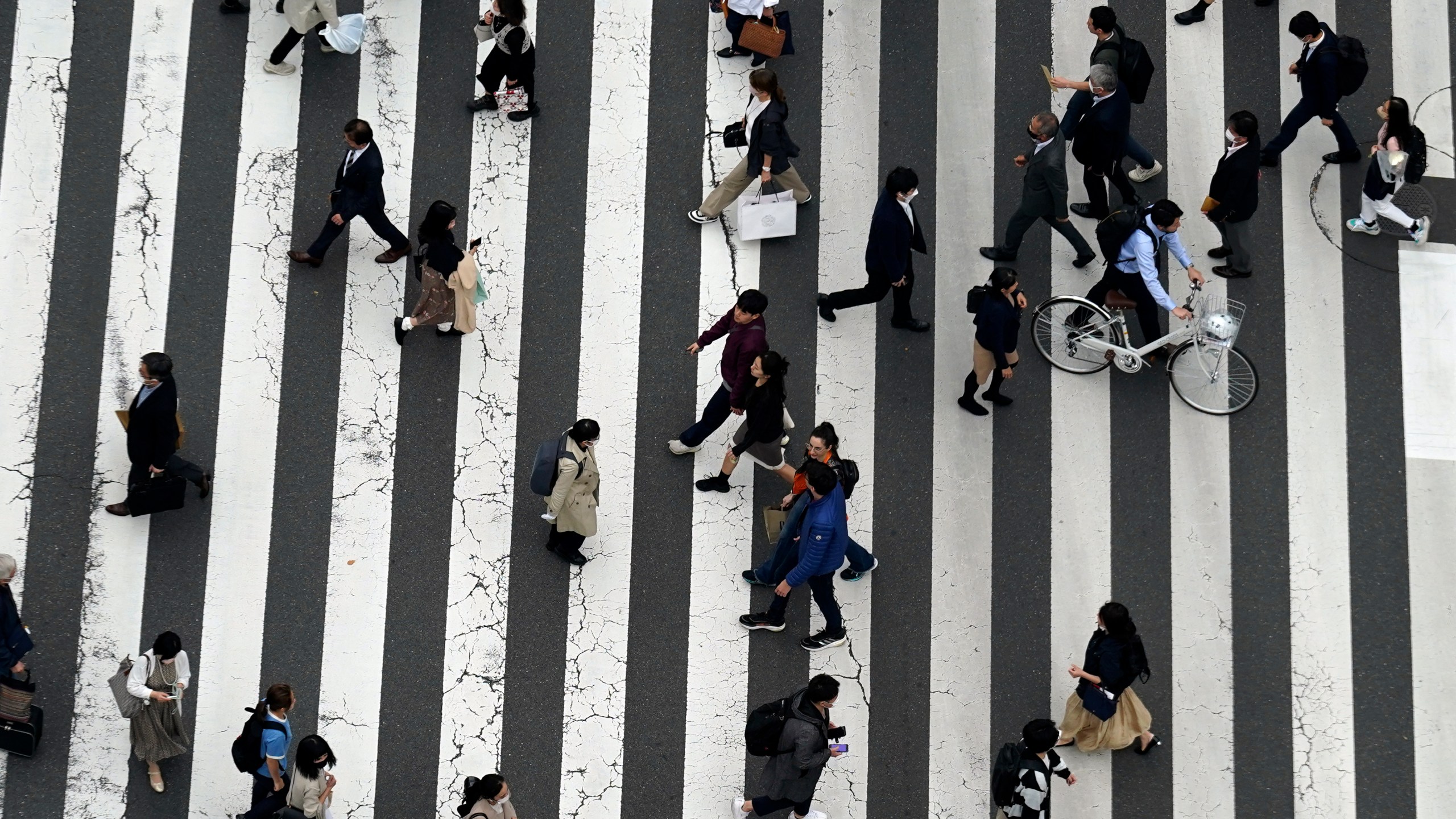 People walk along a pedestrian crossing at Ginza shopping street on March 31, 2023, in Tokyo. Japan's population declined in all of its 47 prefectures for the first time in a record drop, while its number of foreign residents hit a new high, reaching almost 3 million people, according to government data released Wednesday, July 26, 2023, highlighting the increasing role that non-Japanese people play in the shrinking and aging country. (AP Photo/Eugene Hoshiko)