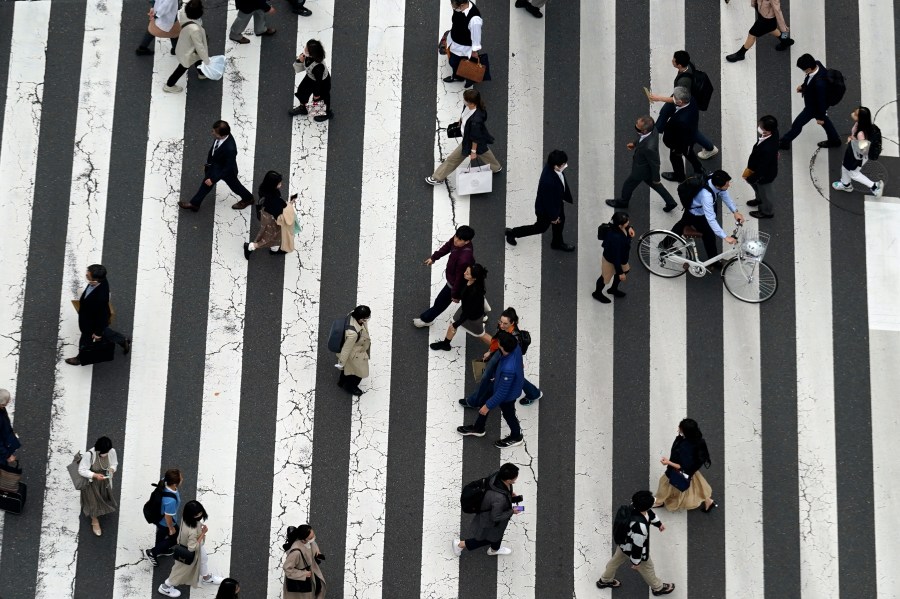 People walk along a pedestrian crossing at Ginza shopping street on March 31, 2023, in Tokyo. Japan's population declined in all of its 47 prefectures for the first time in a record drop, while its number of foreign residents hit a new high, reaching almost 3 million people, according to government data released Wednesday, July 26, 2023, highlighting the increasing role that non-Japanese people play in the shrinking and aging country. (AP Photo/Eugene Hoshiko)