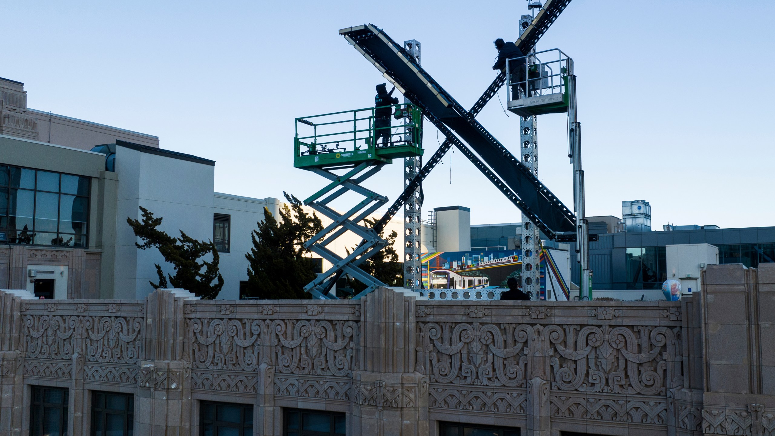 Workers install lighting on an “X” sign atop the company headquarters, formerly known as Twitter, in downtown San Francisco, on Friday, July 28, 2023. The city has launched an investigation into the sign as city officials say replacing letters or symbols on buildings, or erecting a sign on top of one, requires a permit. (AP Photo/Noah Berger)