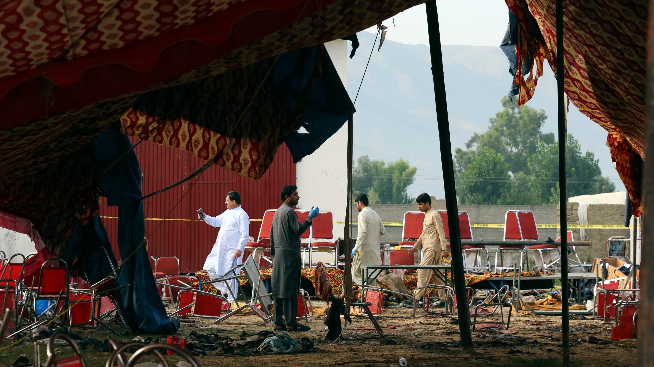 Pakistani investigators inspect at the site of Sunday's suicide bomber attack, in the Bajur district of Khyber Pakhtunkhwa, Pakistan, Monday, July 31, 2023. A suicide bomber blew himself up at a political rally in a former stronghold of militants in northwest Pakistan bordering Afghanistan on Sunday, killing and wounding multiple people in an attack that a senior leader said was meant to weaken Pakistani Islamists. (AP Photo/Mohammad Sajjad)