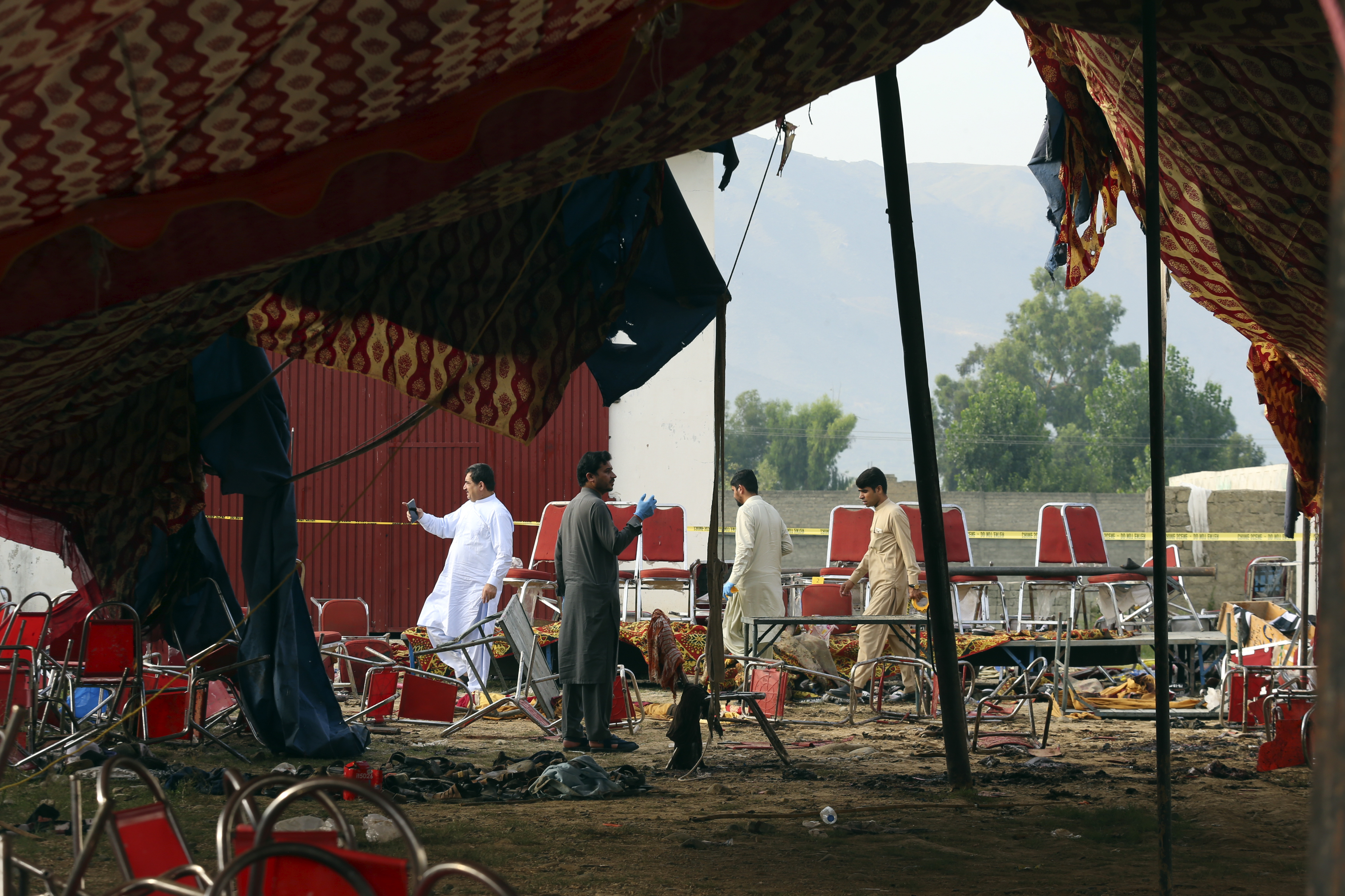 Pakistani investigators inspect at the site of Sunday's suicide bomber attack, in the Bajur district of Khyber Pakhtunkhwa, Pakistan, Monday, July 31, 2023. A suicide bomber blew himself up at a political rally in a former stronghold of militants in northwest Pakistan bordering Afghanistan on Sunday, killing and wounding multiple people in an attack that a senior leader said was meant to weaken Pakistani Islamists. (AP Photo/Mohammad Sajjad)