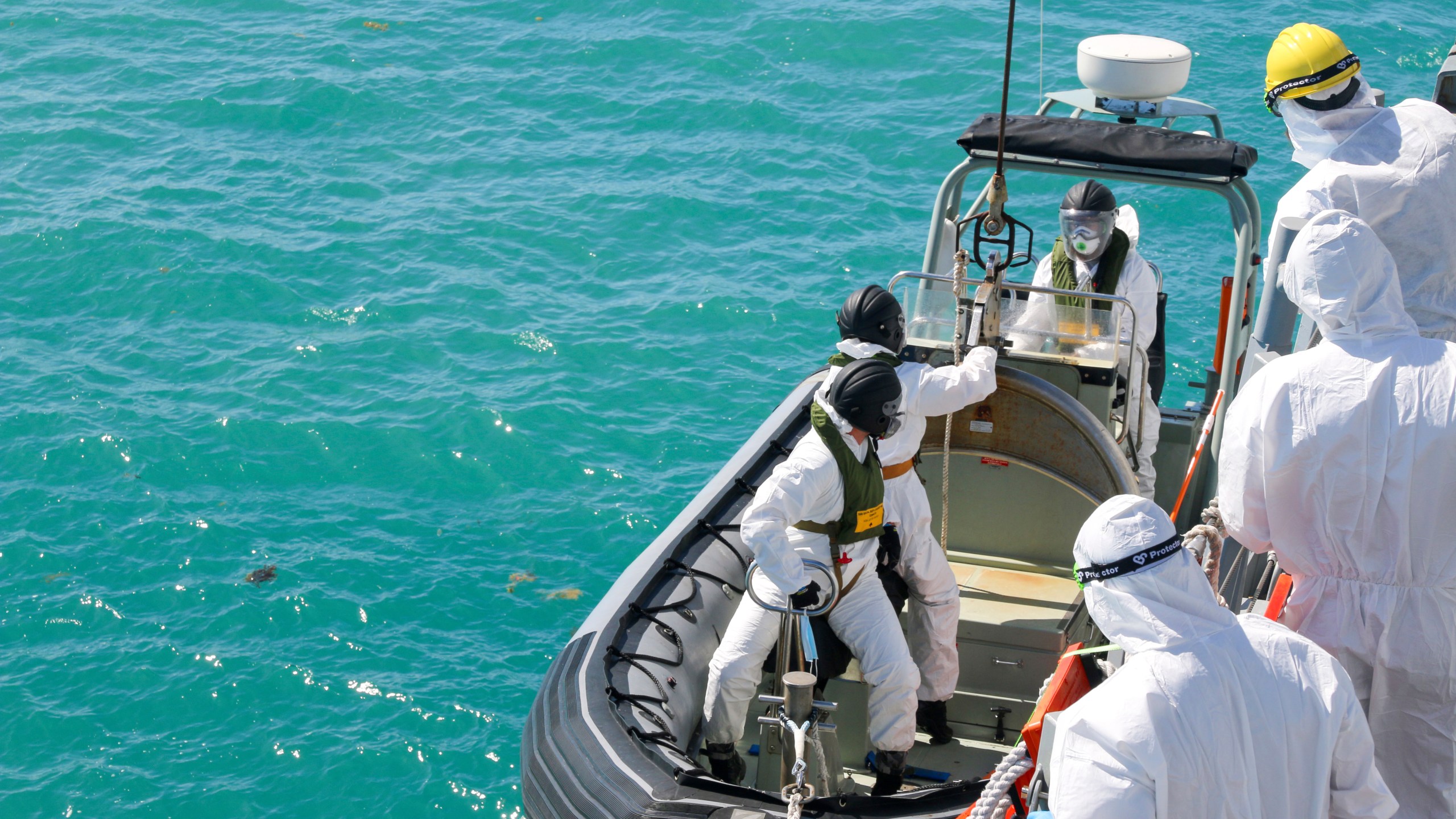 In this photo provided by the Australian Defence Force, sailors from HMAS Brisbane prepare to board a rigid-Hulled inflatable boat to conduct search and rescue operations in the vicinity of Lindeman Island, Australia on Saturday, July 29, 2023, as part of a multi-national and multi-agency search and rescue effort following an Australian Army MRH-90 Taipan helicopter ditching in waters near the island. The helicopter hit the water off Australia's northeast coast with a "catastrophic impact" on Friday and there was no chance that that any of the four air crew would be found alive, officials said on Monday, July 31, 2023. (LSEW Hannah Linsley/ADF via AP)