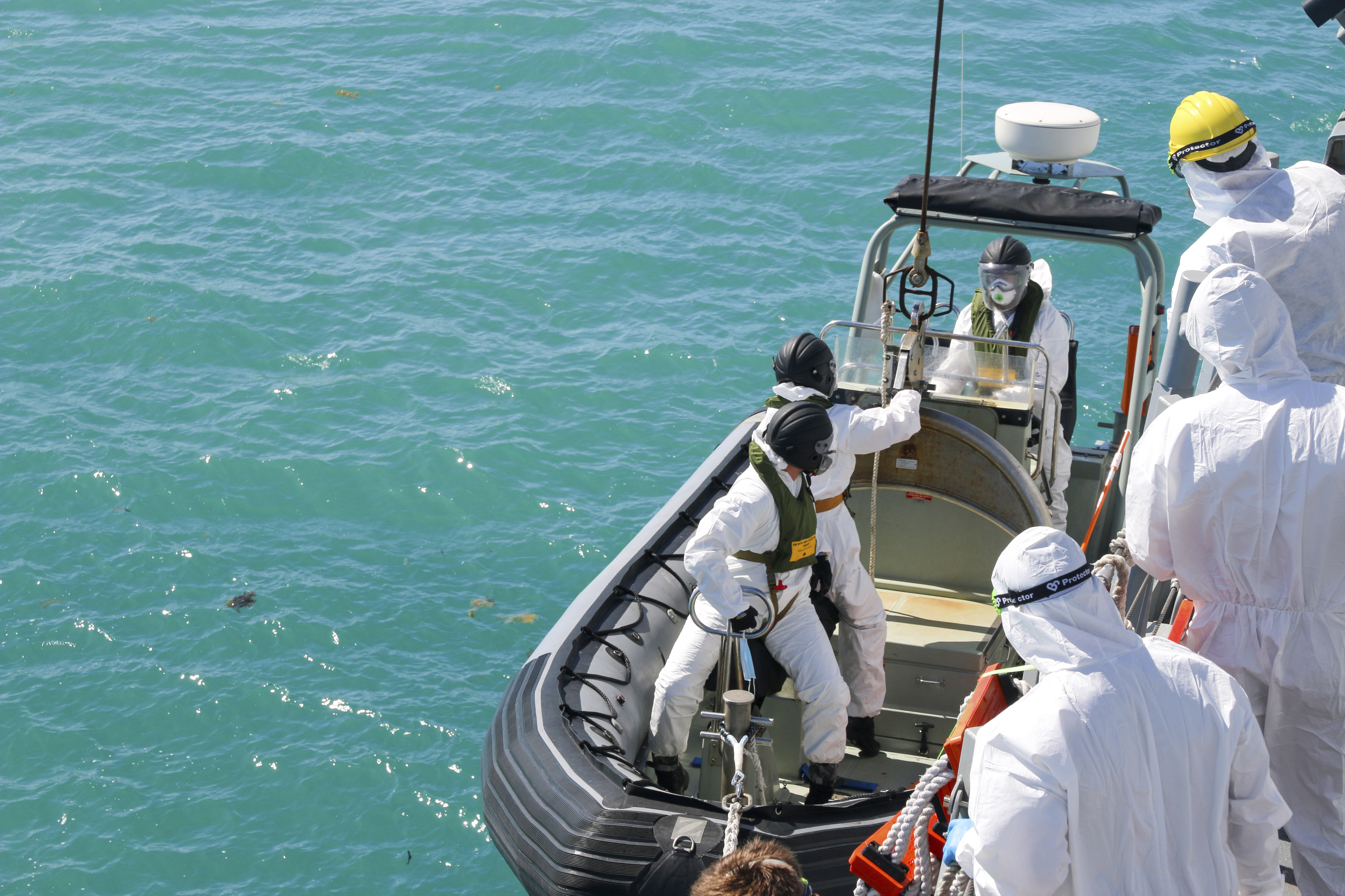 In this photo provided by the Australian Defence Force, sailors from HMAS Brisbane prepare to board a rigid-Hulled inflatable boat to conduct search and rescue operations in the vicinity of Lindeman Island, Australia on Saturday, July 29, 2023, as part of a multi-national and multi-agency search and rescue effort following an Australian Army MRH-90 Taipan helicopter ditching in waters near the island. The helicopter hit the water off Australia's northeast coast with a "catastrophic impact" on Friday and there was no chance that that any of the four air crew would be found alive, officials said on Monday, July 31, 2023. (LSEW Hannah Linsley/ADF via AP)