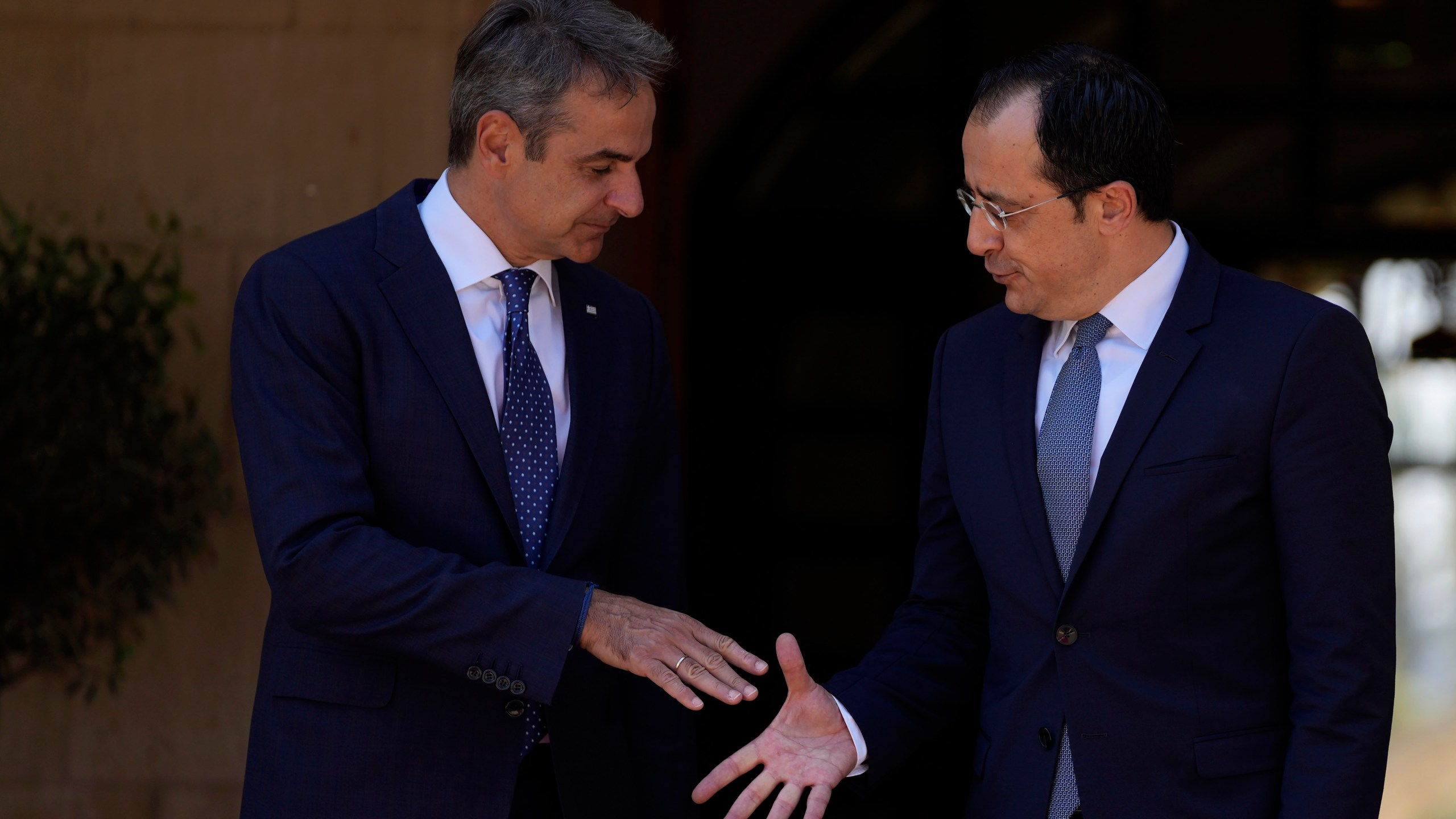 Cyprus' President Nikos Christodoulides, right, and Greek Prime Minister Kyriakos Mitsotakis, left, shake hands before their meeting at the Presidential Palace in Nicosia, Cyprus, on Monday, July 31, 2023. Mitsotakis is in Cyprus for an official visit. (AP Photo/Petros Karadjias)