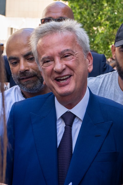 Riad Salameh, Lebanon's outgoing Central Bank governor, greets employees at a farewell ceremony marking the end of his 30 years in office outside the Central Bank building, in Beirut, Monday, July 31, 2023. Meanwhile, his four vice governors, led by incoming interim governor Wassim Mansouri, urged the cash-strapped country's government for fiscal reforms at a news conference in that same building. (AP Photo/Hassan Ammar)