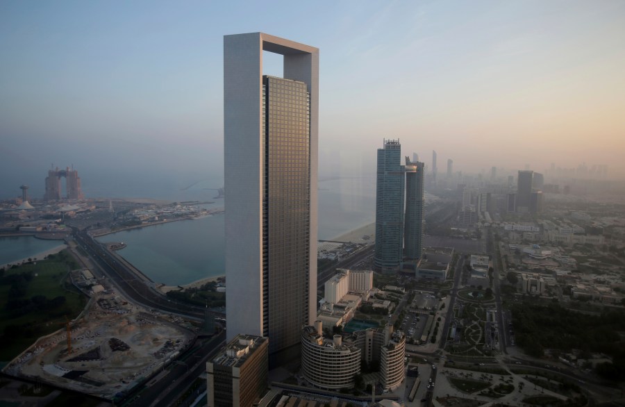 FILE - The sun rises over the headquarters of the Abu Dhabi National Oil Co. headquarters that dominates the skyline in Abu Dhabi, United Arab Emirates, on Nov. 7, 2016. The state-run oil giant in the United Arab Emirates, ADNOC, said Monday July 31, 2023 it has moved up its target for achieving net zero emissions in its operations to 2045, as the country prepares to host U.N. climate talks later this year. (AP Photo/Kamran Jebreili, File)