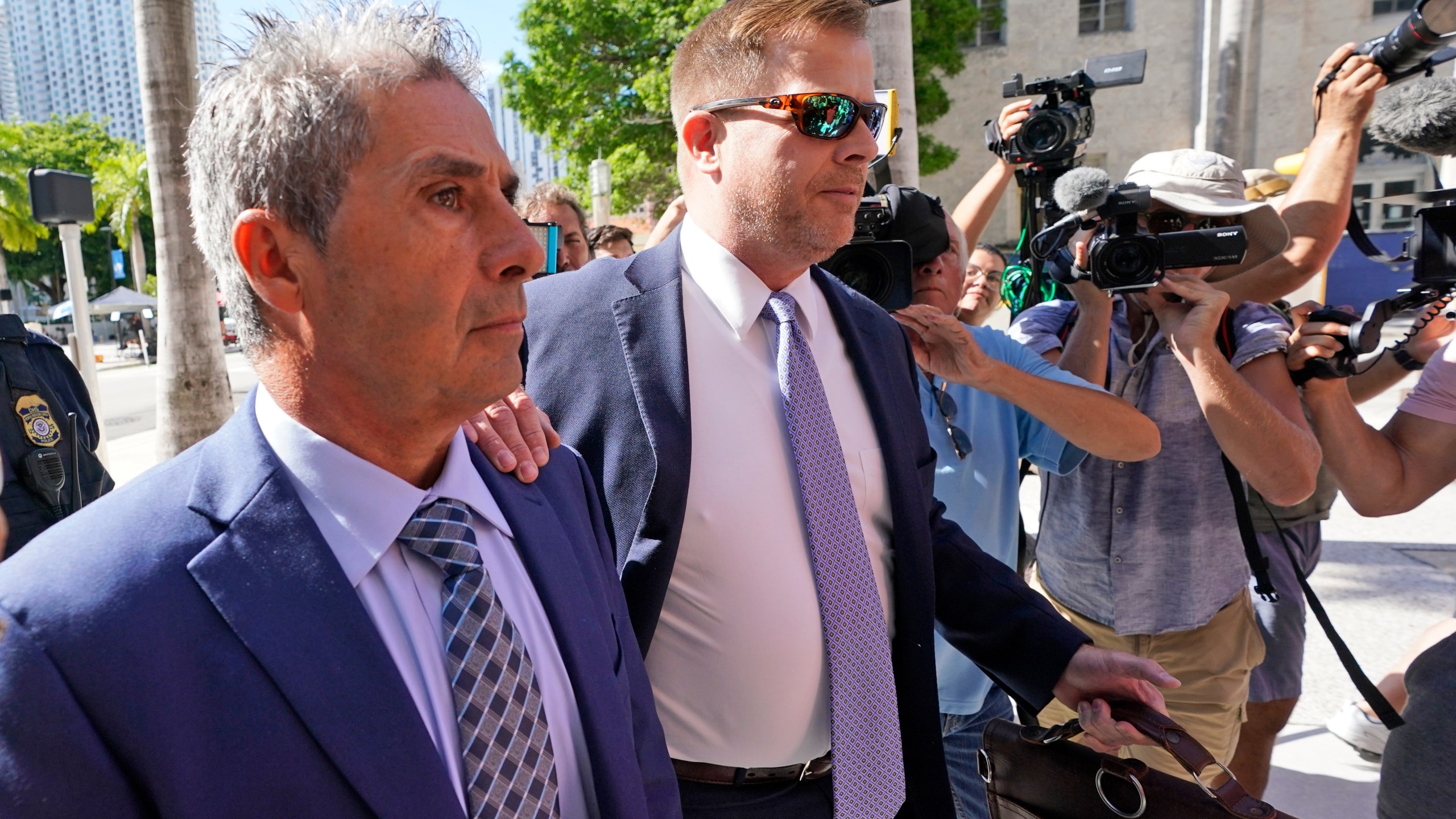 Carlos De Oliveira, left, an employee of Donald Trump's Mar-a-Lago estate, arrives for a court appearance with attorney John Irving, at the James Lawrence King Federal Justice Building, Monday, July 31, 2023, in Miami. De Oliveira, Mar-a-Lago's property manager, was added last week to the indictment with Trump and the former president's valet, Walt Nauta, in the federal case alleging a plot to illegally keep top-secret records at Trump's Florida estate and thwart government efforts to retrieve them. (AP Photo/Wilfredo Lee)