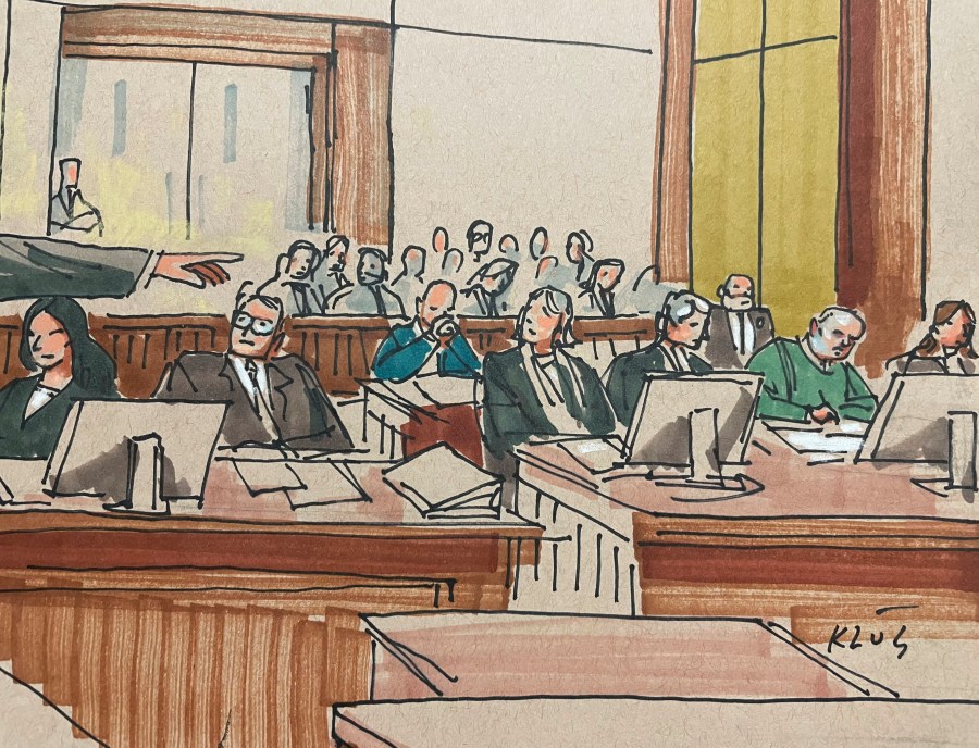 U.S. Attorney Eric Olshan, hand at left, argues before a federal jury that 2018 Pittsburgh synagogue attack defendant Robert Bowers should receive the death penalty, Monday July 31, 2023. Bowers, wearing green, was previously found guilty of killing 11 people in the deadliest antisemitic attack in U.S. history. (Dave Klug via AP)