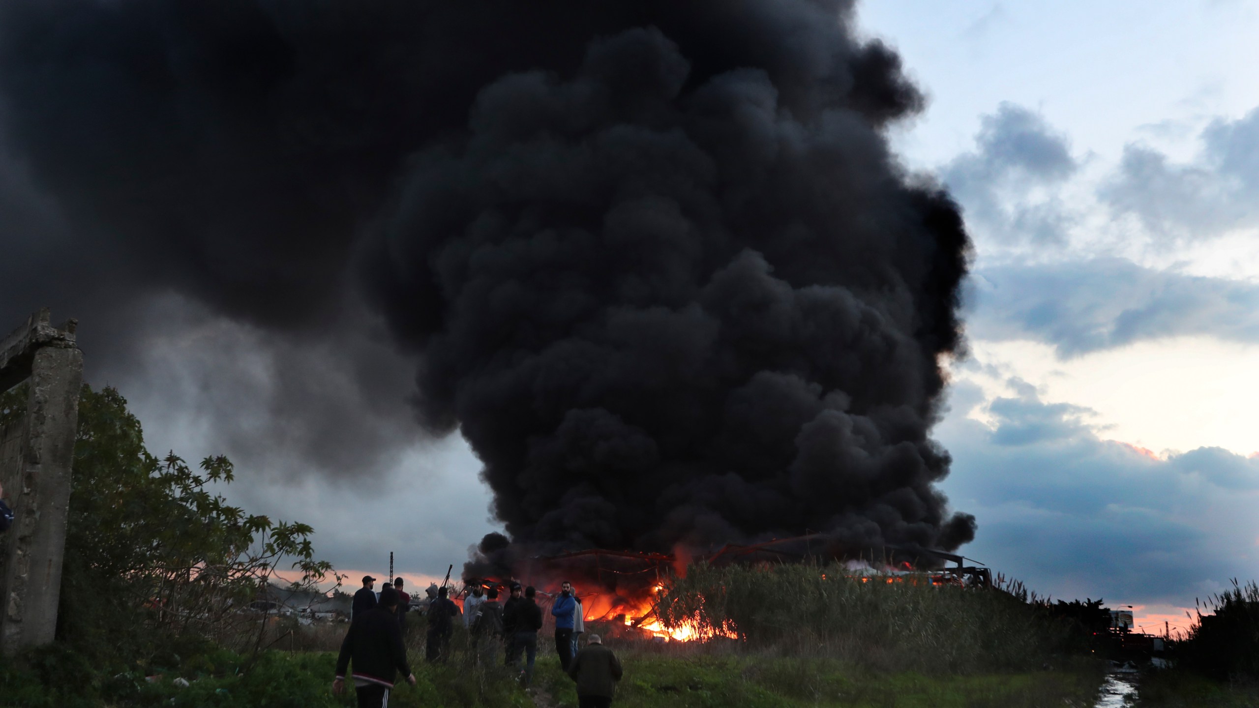 Black smoke and flames rise from a burning warehouse, attacked by Israeli strikes, at an industrial district, in the southern coastal town of Ghazieh, Lebanon, Monday, Feb. 19, 2024. Israel's air force carried out at least two airstrikes near the southern port city of Sidon in one of the largest attacks near a major city, state media reported. (AP Photo/Mohammed Zaatari)