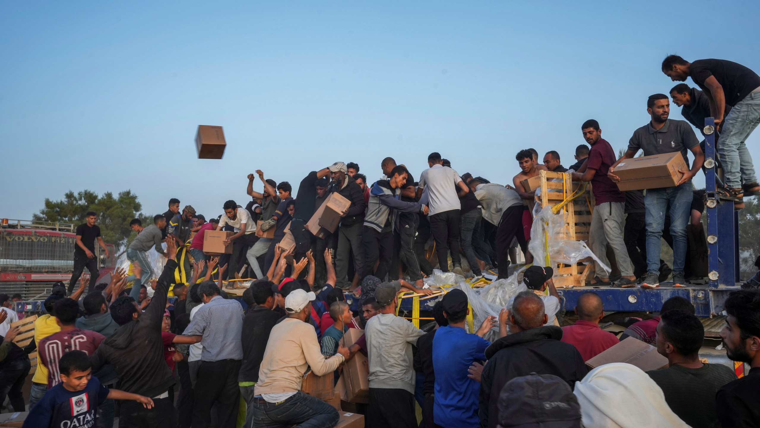 FILE - Palestinians are storming trucks loaded with humanitarian aid brought in through a new U.S.-built pier, in the central Gaza Strip, Saturday, May 18, 2024. United Nations agencies are warning, Wednesday, June 5, that over 1 million Palestinians in the Gaza Strip could experience the highest level of life-threatening starvation by the middle of next month if hostilities continue. (AP Photo/Abdel Kareem Hana, File)