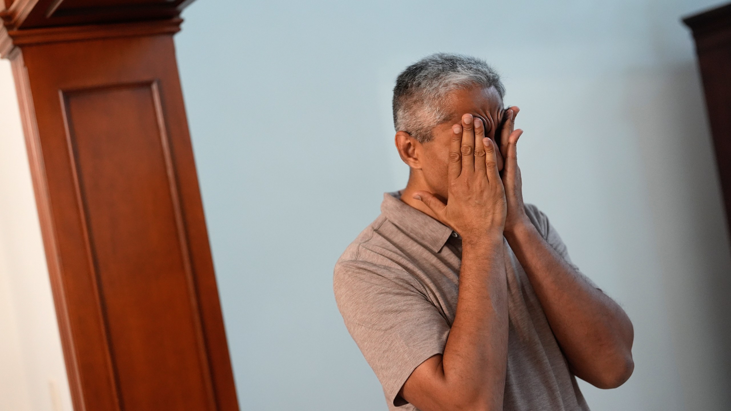 Surgeon General Dr. Vivek Murthy rubs his temples as he transitions from work to family life, during a visit to his parents' home, Tuesday, July 16, 2024, near Miami, Fla. (AP Photo/Rebecca Blackwell)