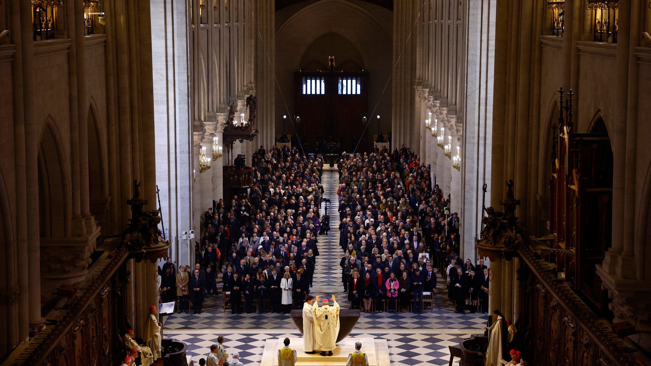 Archbishop Laurent Ulrich, center, blesses the altar during an inaugural Mass, with the consecration of the high altar, at the Notre-Dame de Paris Cathedral, five-and-a-half years after a fire ravaged the Gothic masterpiece, as part of ceremonies to mark the Cathedral's reopening after its restoration, in Paris, France, Sunday, Dec. 8, 2024. (Sarah Meyssonnier/Pool Photo via AP)