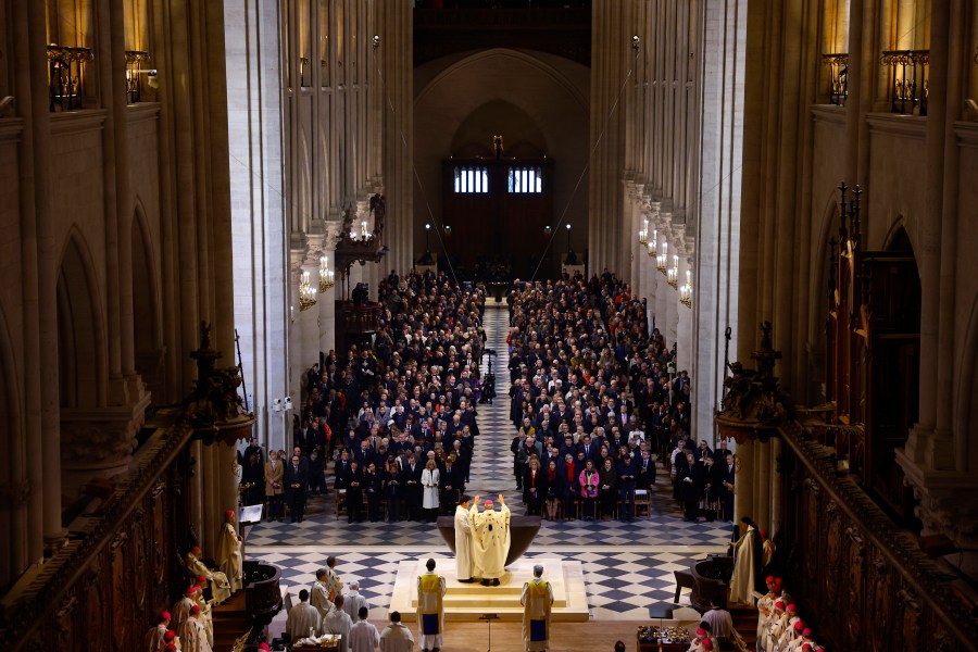 Archbishop Laurent Ulrich, center, blesses the altar during an inaugural Mass, with the consecration of the high altar, at the Notre-Dame de Paris Cathedral, five-and-a-half years after a fire ravaged the Gothic masterpiece, as part of ceremonies to mark the Cathedral's reopening after its restoration, in Paris, France, Sunday, Dec. 8, 2024. (Sarah Meyssonnier/Pool Photo via AP)