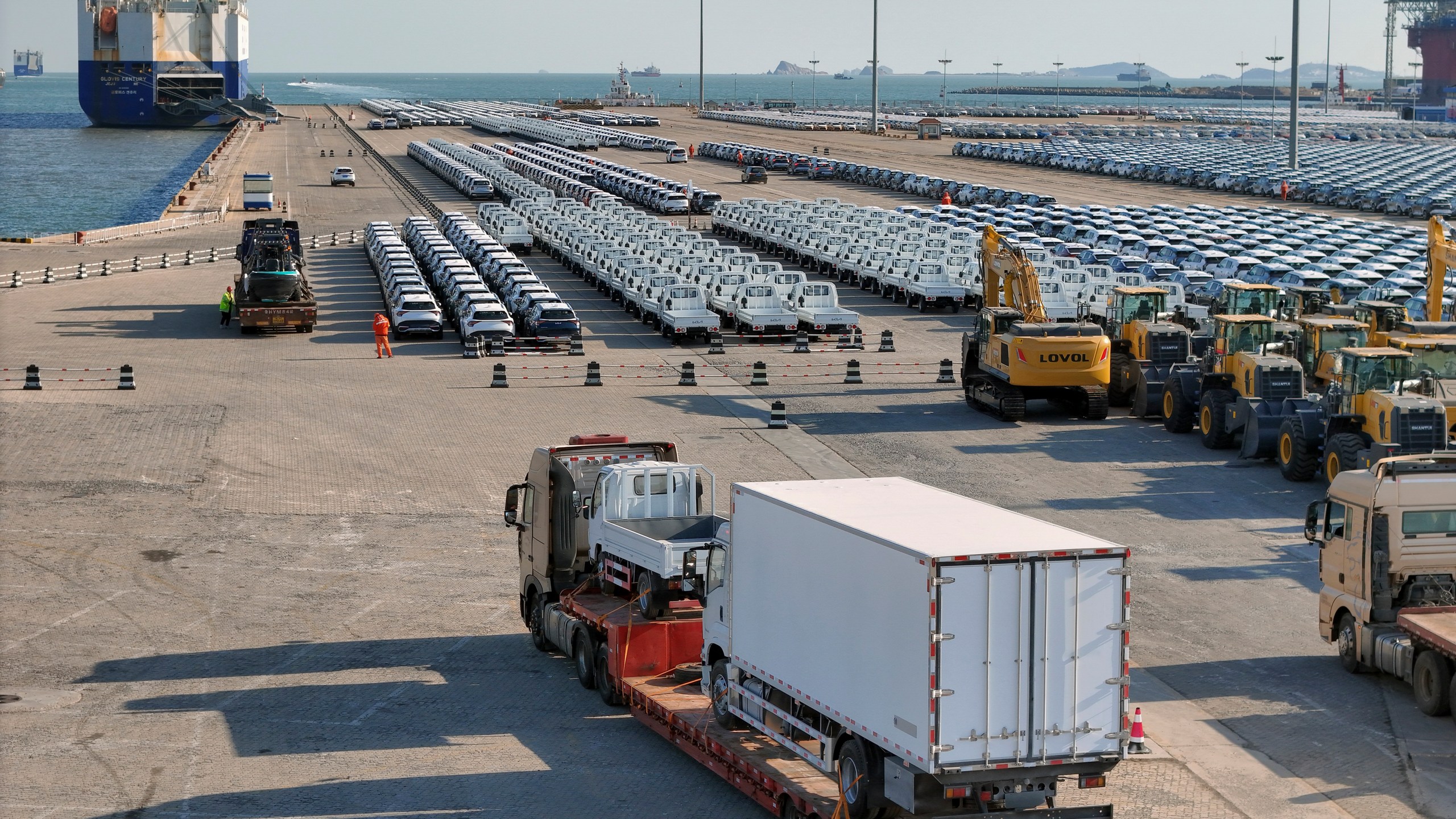 A truck loaded with vehicles moves to lines of vehicles for export at a port in Yantai in eastern China's Shandong province on Jan. 2, 2025. (Chinatopix via AP)