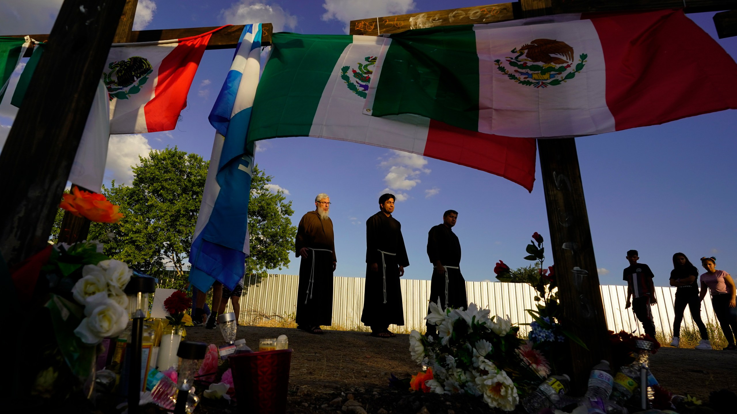 FILE - People visit a makeshift memorial honoring the victims and survivors of a human smuggling tragedy, where dozens of migrants were found in an airless tractor-trailer rig, in San Antonio, July 6, 2022. (AP Photo/Eric Gay, File)