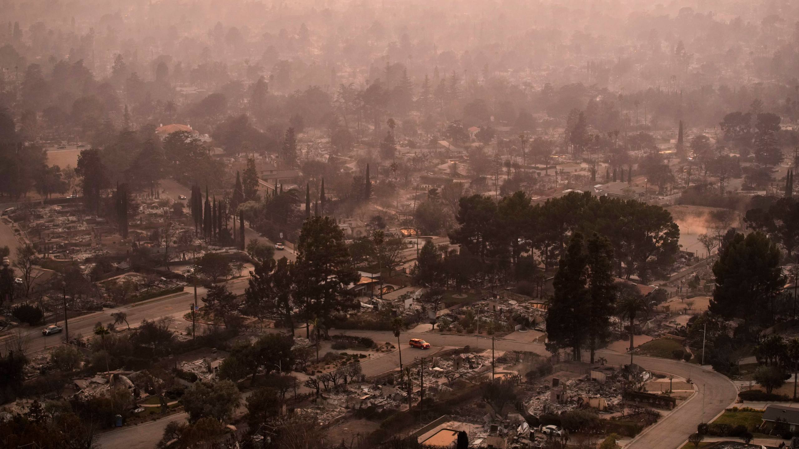 FILE - Smoke lingers over a neighborhood devastated by the Eaton Fire, Jan. 9, 2025, in Altadena, Calif. (AP Photo/John Locher, File)