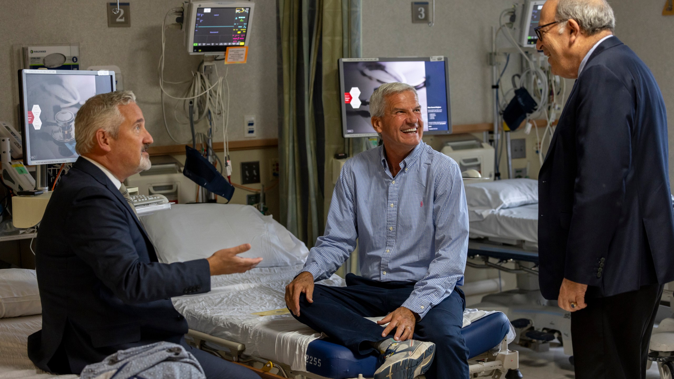 In this photo provided by Massachusetts General Hospital, patient Mike Garrity, center, speaks with Drs. Joe Garasic, left, and Randy Zusman in Boston, on Sept. 25, 2024. (Jeffrey Andree/Massachusetts General Hospital via AP)