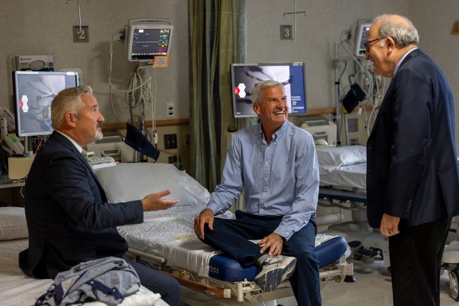 In this photo provided by Massachusetts General Hospital, patient Mike Garrity, center, speaks with Drs. Joe Garasic, left, and Randy Zusman in Boston, on Sept. 25, 2024. (Jeffrey Andree/Massachusetts General Hospital via AP)