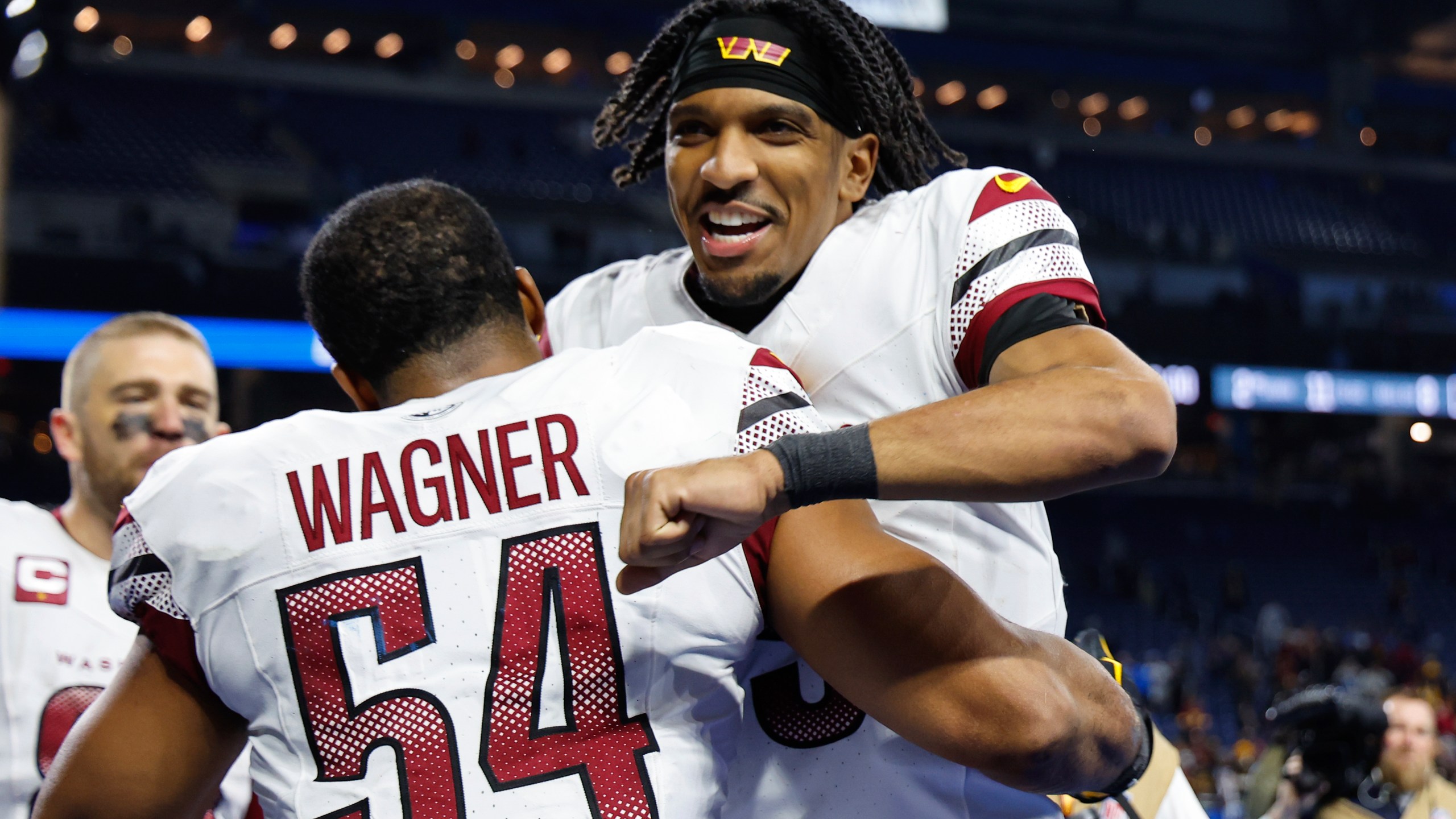 Washington Commanders quarterback Jayden Daniels celebrates with Bobby Wagner (54) after an NFL football divisional playoff game against the Detroit Lions, Saturday, Jan. 18, 2025, in Detroit. (AP Photo/Rey Del Rio)