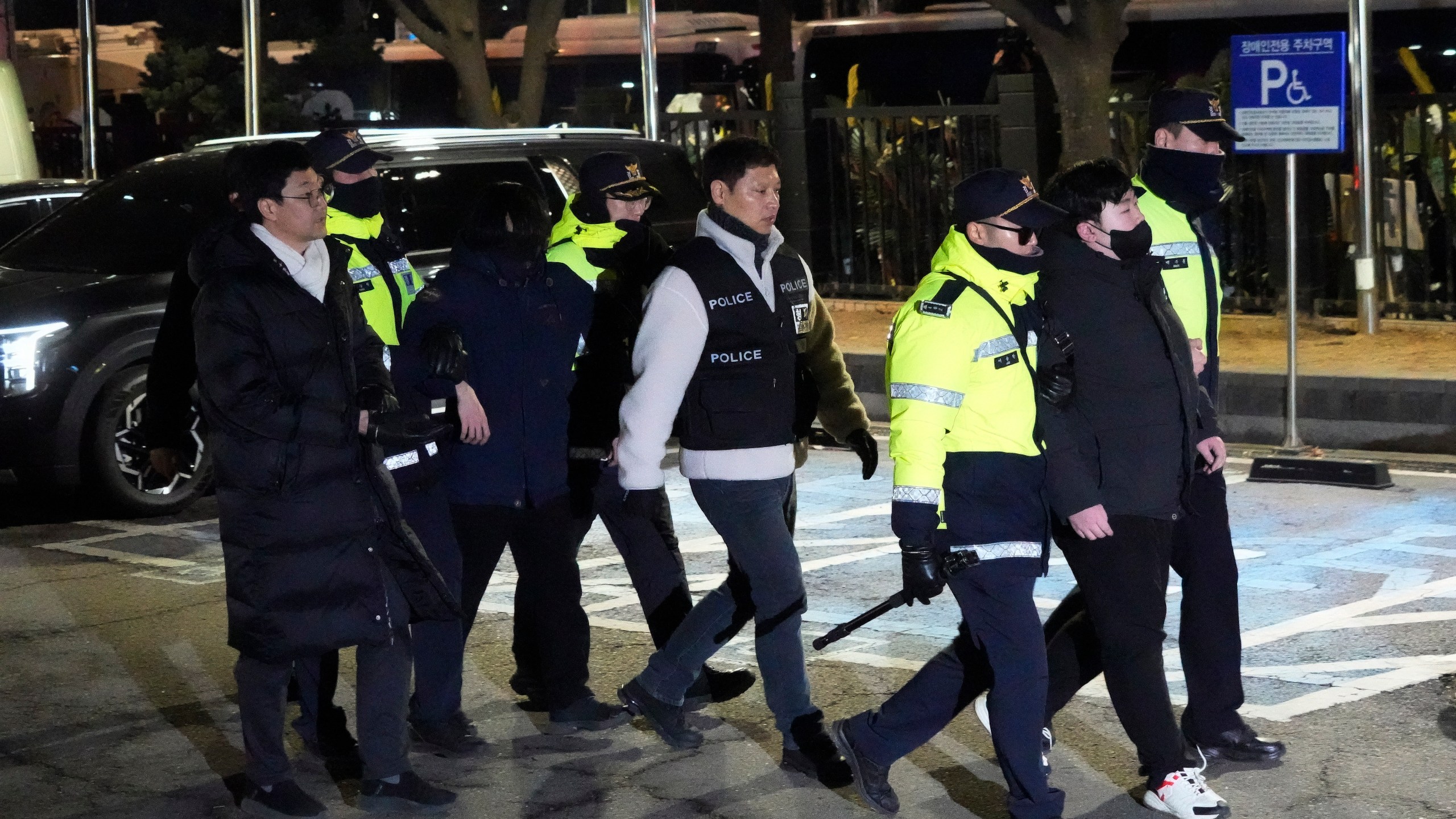 Police officers detain supporters of impeached South Korean President Yoon Suk Yeol after they illegally climbed over a fence inside the Seoul Western District Court in Seoul, South Korea, Saturday, Jan. 18, 2025. (AP Photo/Ahn Young-joon)