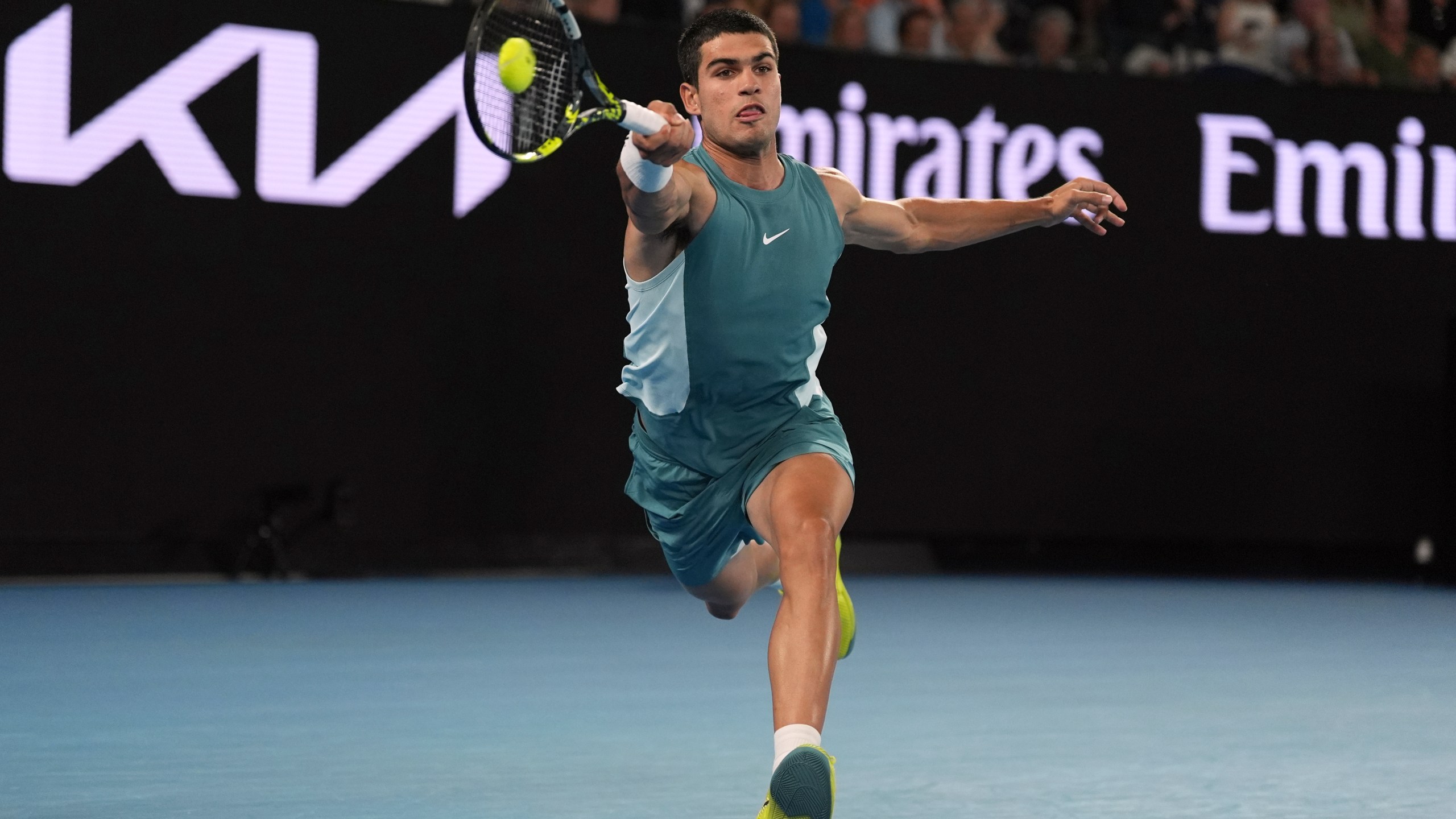 Carlos Alcaraz of Spain plays a forehand return to Novak Djokovic of Serbia during their quarterfinal match at the Australian Open tennis championship in Melbourne, Australia, Tuesday, Jan. 21, 2025. (AP Photo/Ng Han Guan)