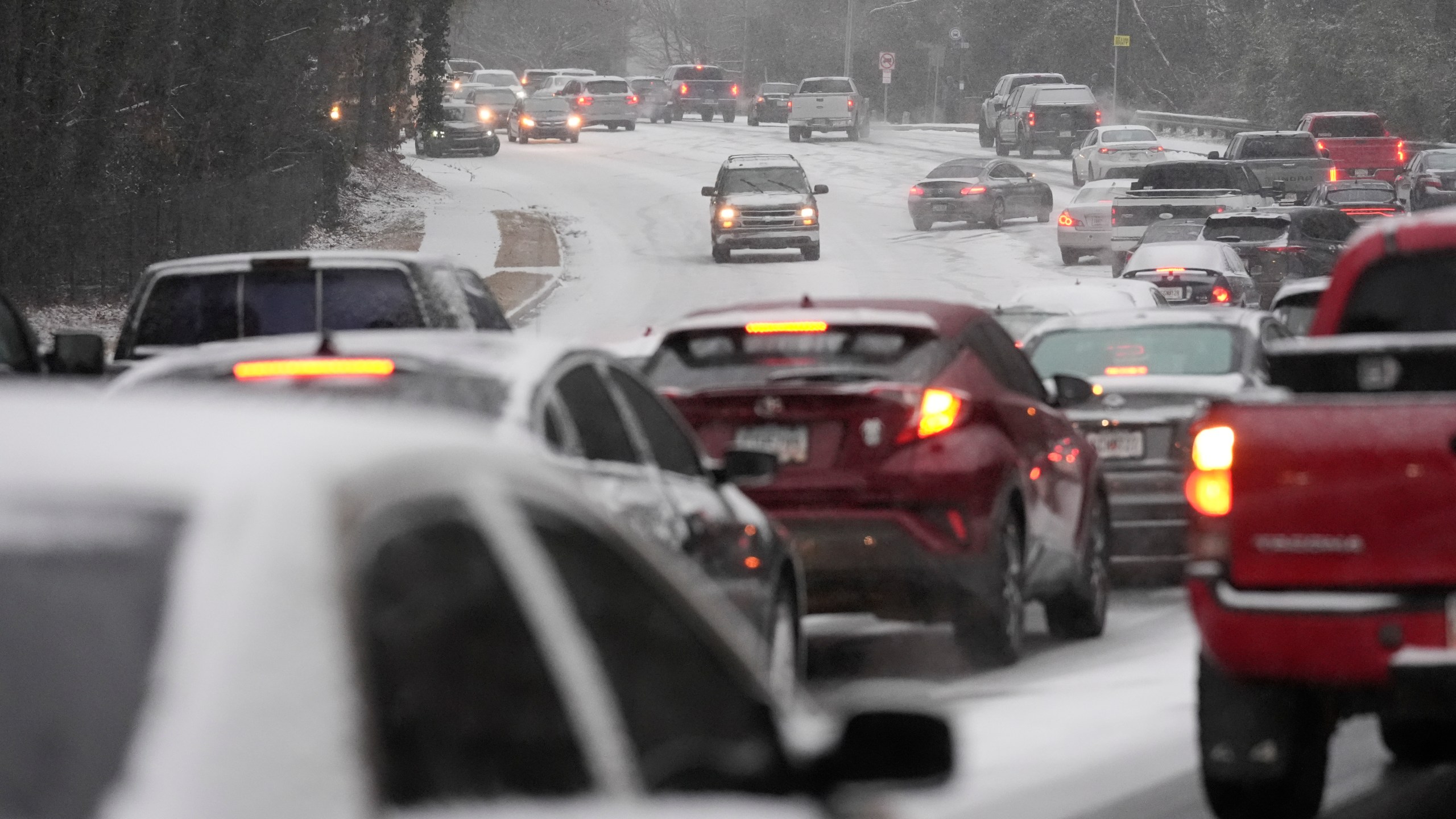 Cars backup near a hill with snow and ice on the road during a winter storm on Tuesday, Jan. 21, 2025, in Tucker, Ga. (AP Photo/Brynn Anderson)