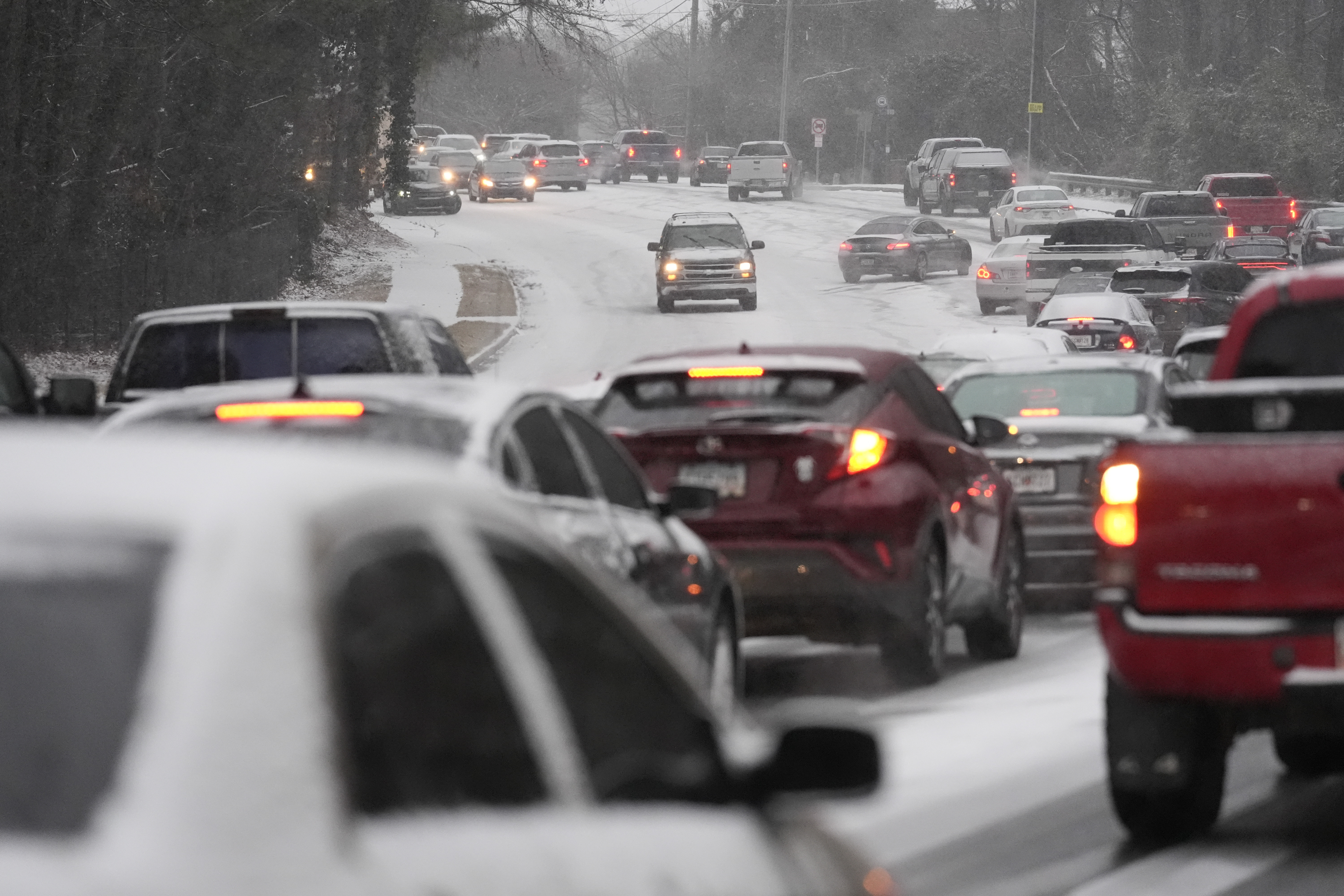 Cars backup near a hill with snow and ice on the road during a winter storm on Tuesday, Jan. 21, 2025, in Tucker, Ga. (AP Photo/Brynn Anderson)