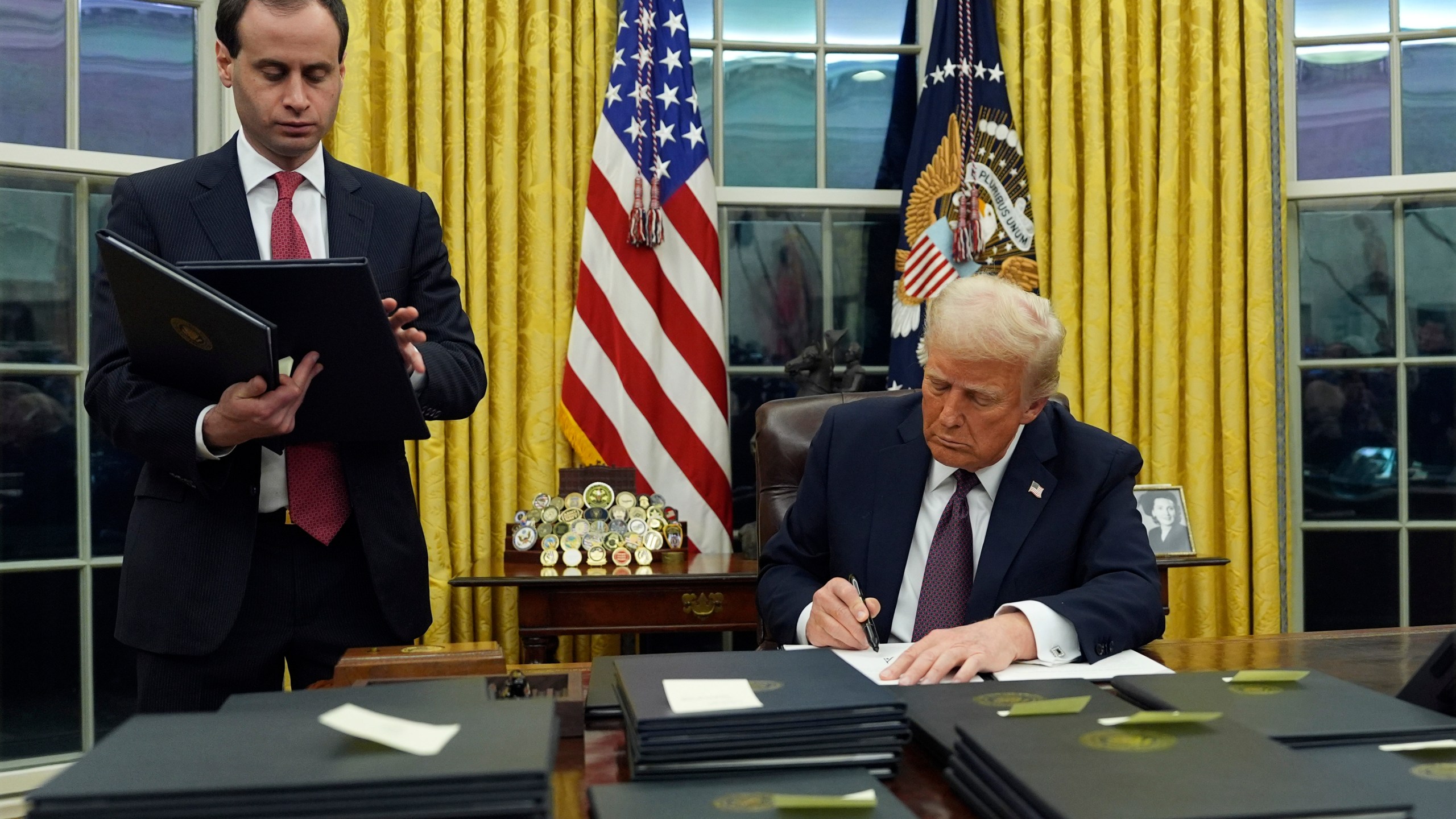 President Donald Trump signs an executive order regarding the southern border in the Oval Office of the White House, Monday, Jan. 20, 2025, in Washington. (AP Photo/Evan Vucci)