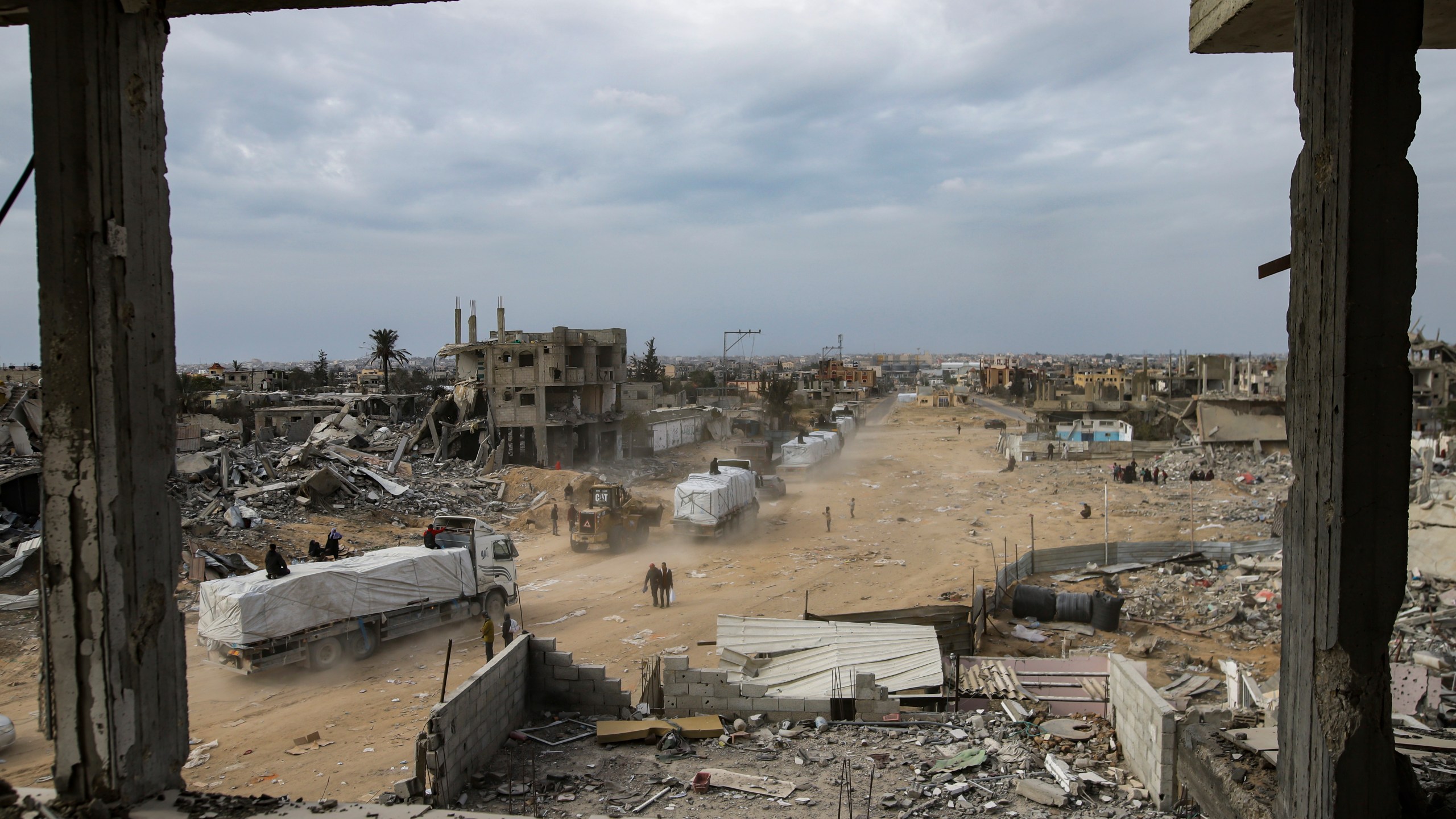 Humanitarian aid trucks enter through the Kerem Shalom crossing from Egypt into the Gaza Strip, in Rafah, Wednesday, Jan. 22, 2025, days after the ceasefire deal between Israel and Hamas came into effect. (AP Photo/Jehad Alshrafi)