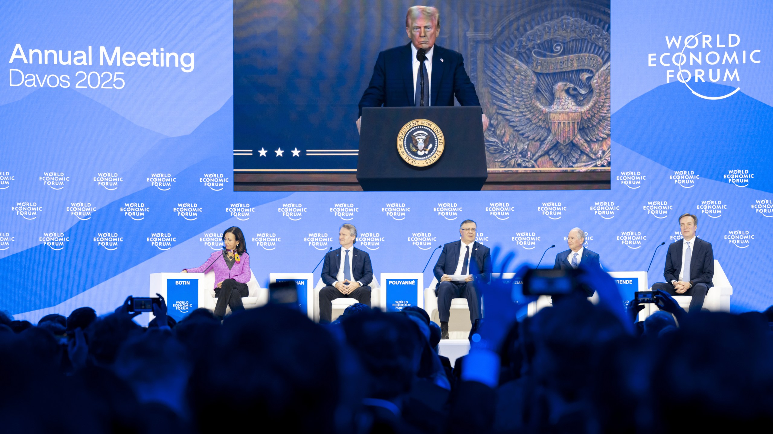 US President Donald J. Trump is shown on screens as he addresses via remote connection a plenary session in the Congress Hall, during the 55th annual meeting of the World Economic Forum (WEF), in Davos, Switzerland, Thursday, Jan. 23, 2025. (Michael Buholzer/Keystone via AP)