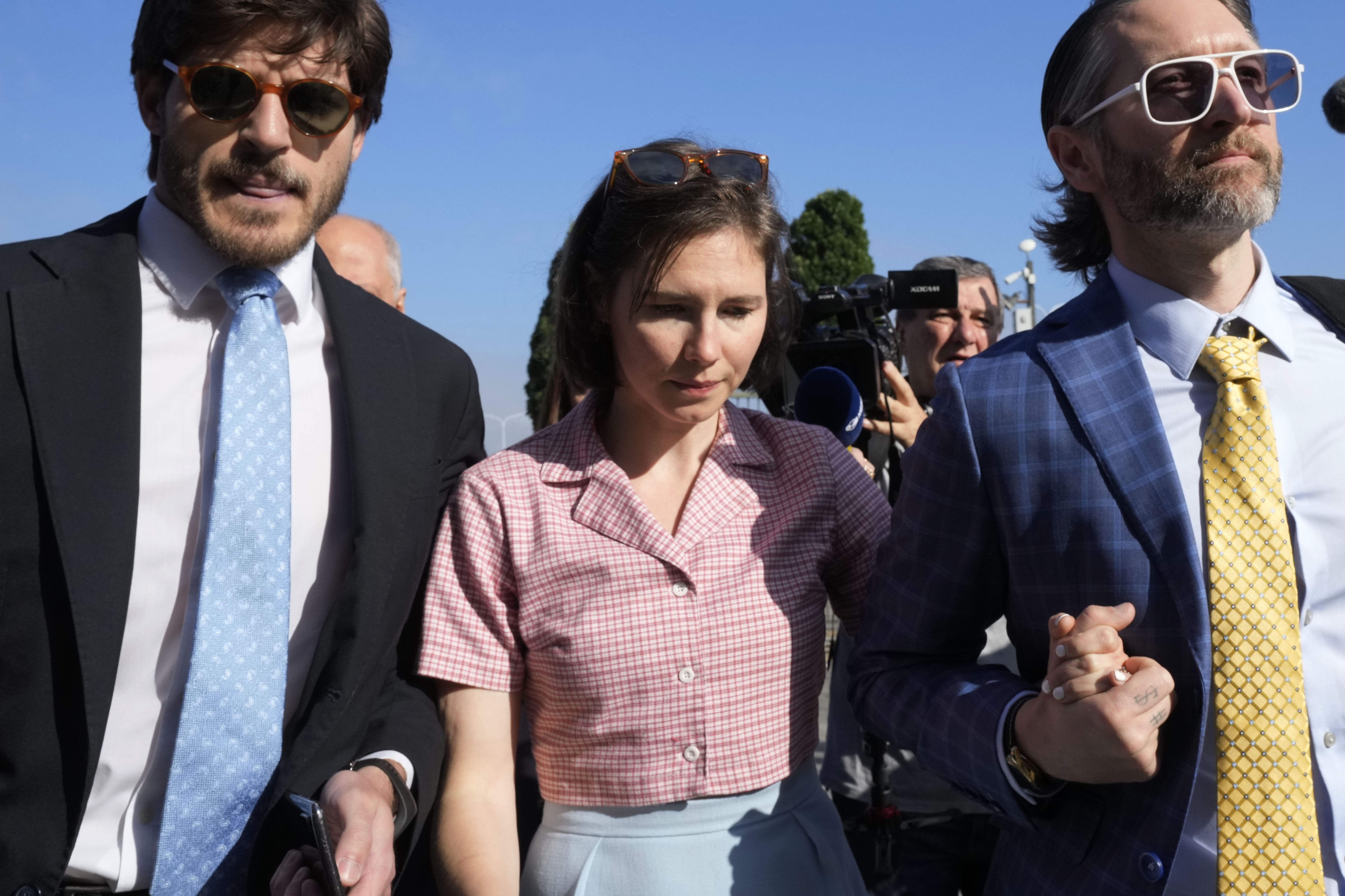 FILE - Amanda Knox arrives flanked by her husband Christopher Robinson, right, at the Florence courtroom in Florence, Italy, Wednesday, June 5, 2024. (AP Photo/Antonio Calanni, File)