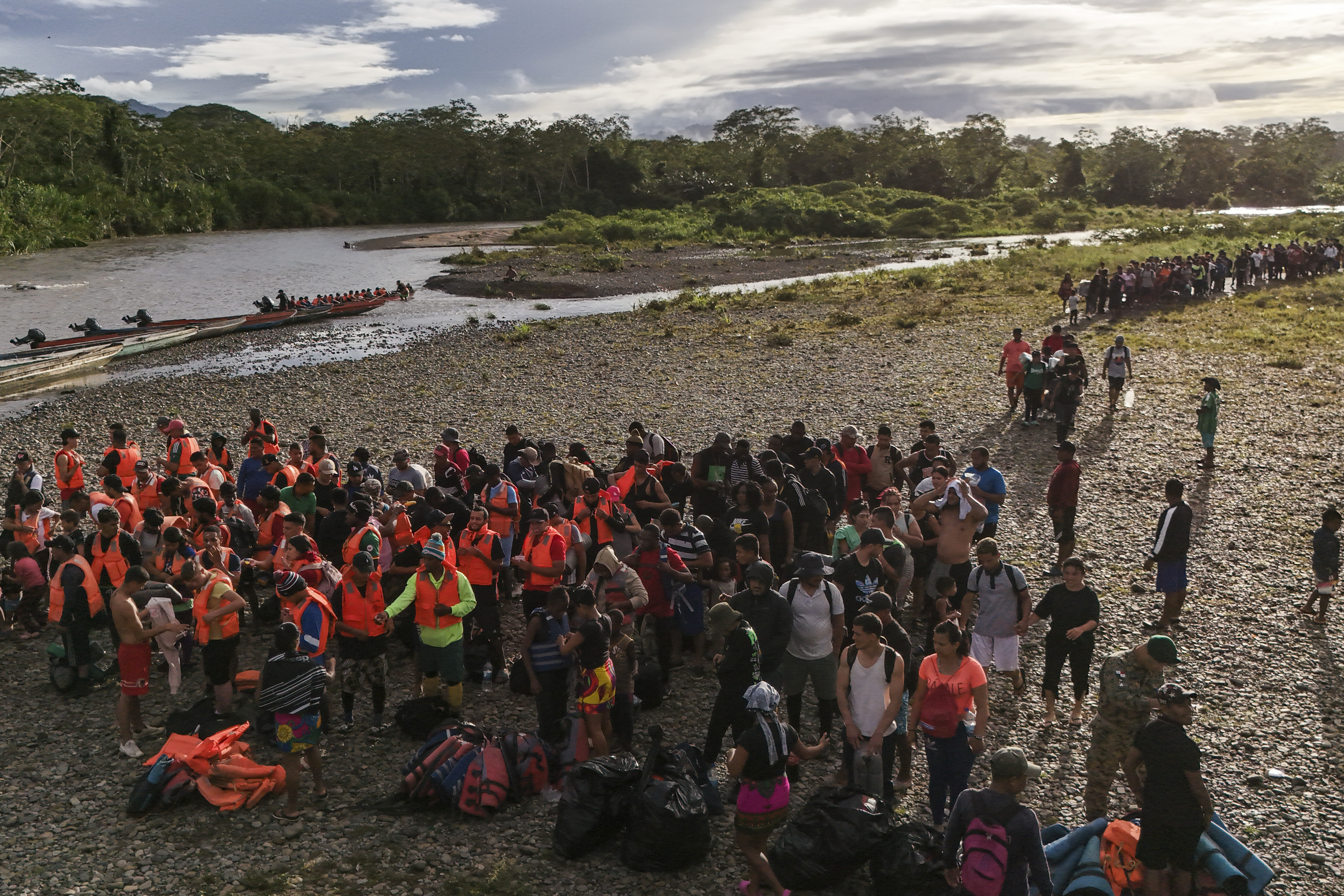 FILE - Migrants line up to board boats to continue their journey north hoping to reach the United States after walking across the Darien Gap from Colombia in Bajo Chiquito, Panama, Nov. 9, 2024. (AP Photo/Matias Delacroix, File)