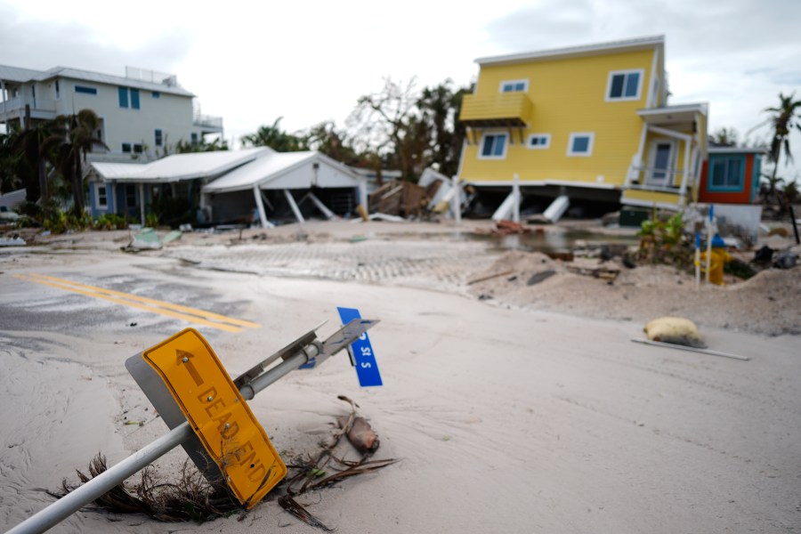 FILE - A house sits toppled off its stilts after the passage of Hurricane Milton, alongside an empty lot where a home was swept away by Hurricane Helene, in Bradenton Beach on Anna Maria Island, Florida, Oct. 10, 2024. (AP Photo/Rebecca Blackwell, File)