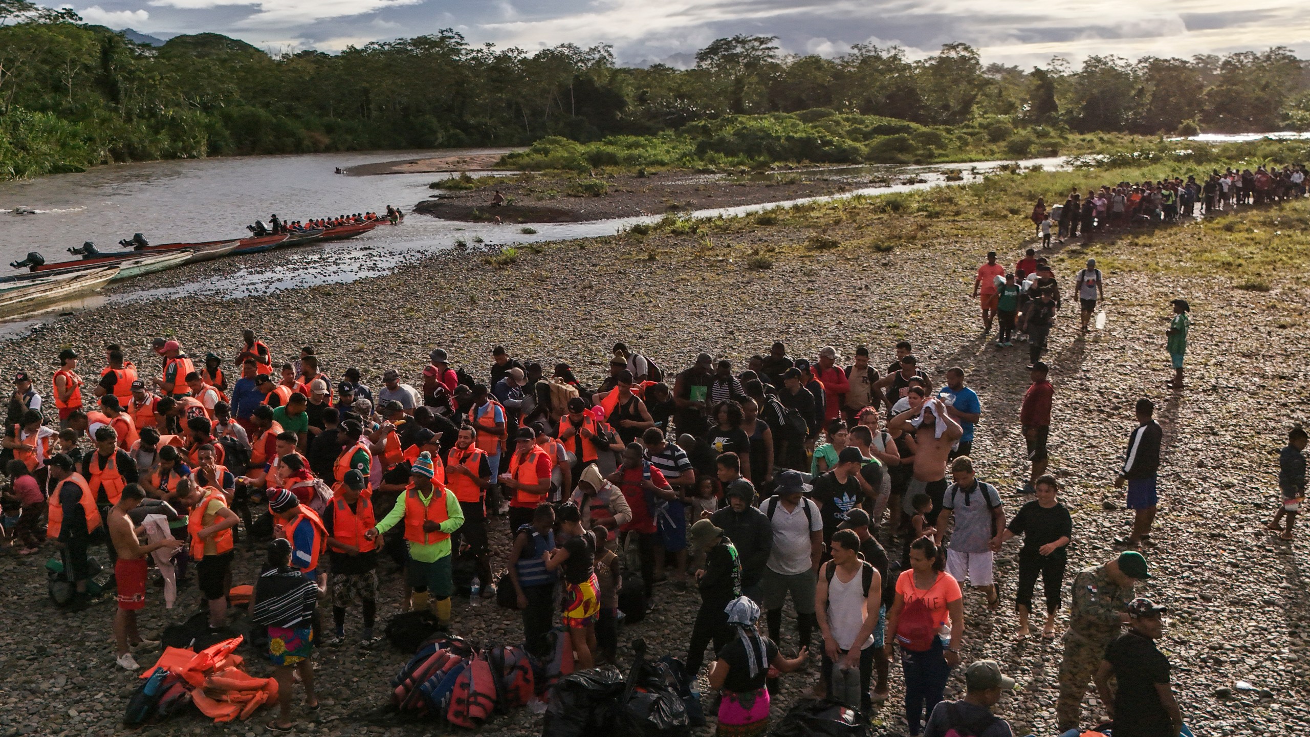 ARCHIVO - Migrantes se forman para abordar botes y poder continuar con su viaje hacia el norte para llegar a la frontera de Estados Unidos tras atravesar la región del Darién desde Colombia, en Bajo Chiquito, Panamá, el 9 de noviembre de 2024. (AP Foto/Matias Delacroix, Archivo)