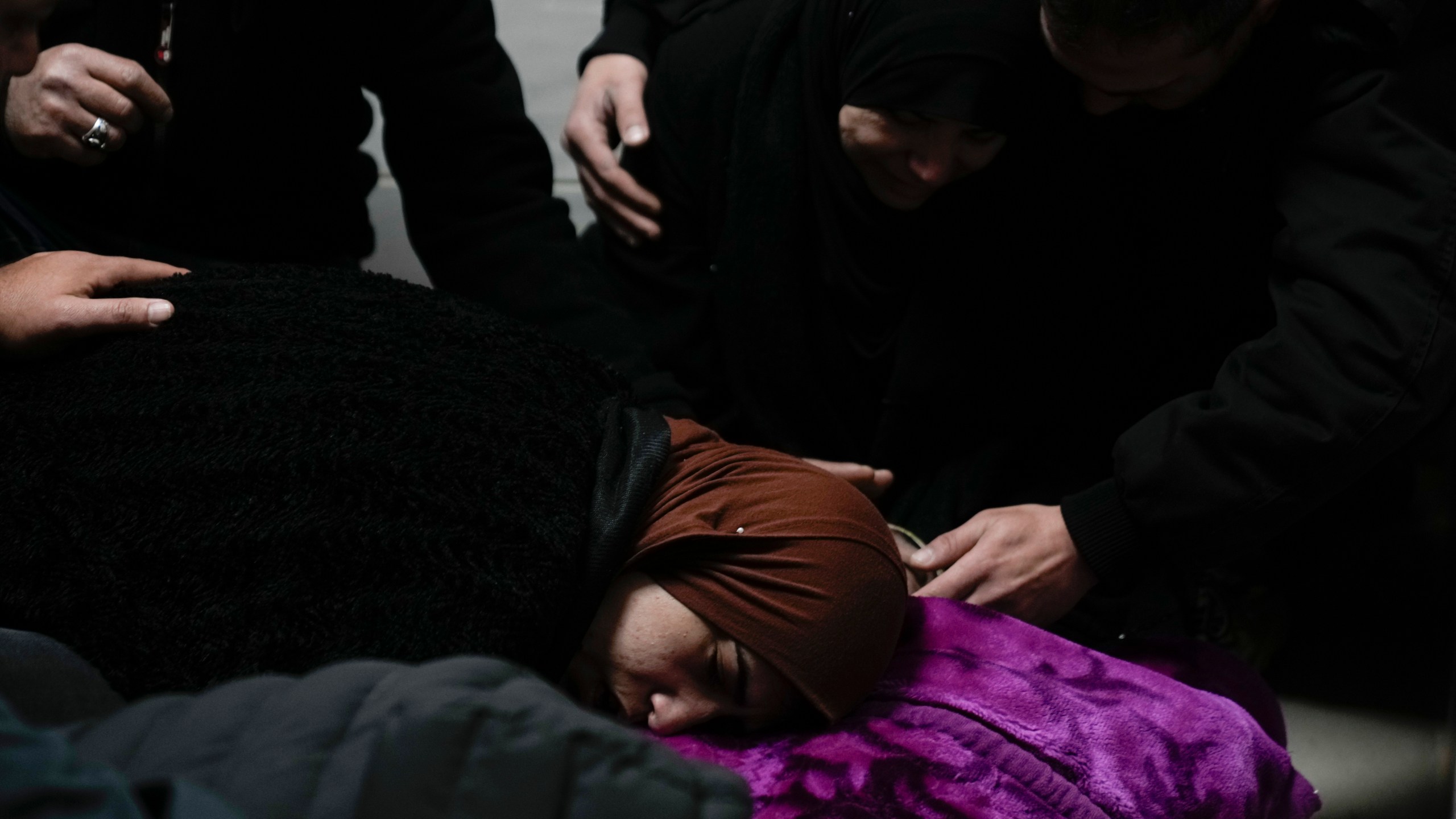 Relatives mourn over the body of Khalil Al-Saadi, 35, before his funeral, almost two weeks after he was killed in an Israeli army raid, in the hospital morgue in Jenin, West Bank, Sunday, Feb. 2, 2025. (AP Photo/Majdi Mohammed)