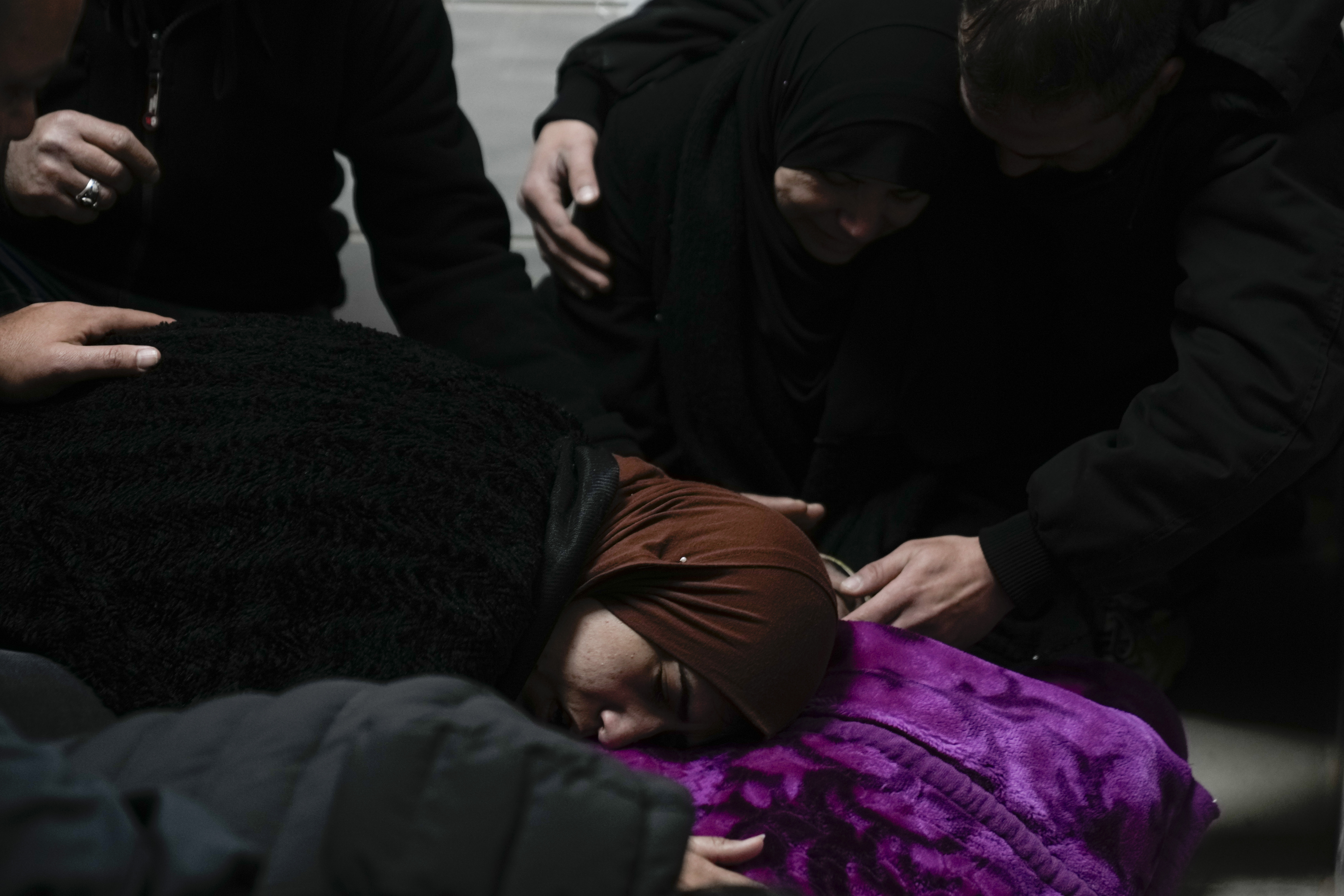 Relatives mourn over the body of Khalil Al-Saadi, 35, before his funeral, almost two weeks after he was killed in an Israeli army raid, in the hospital morgue in Jenin, West Bank, Sunday, Feb. 2, 2025. (AP Photo/Majdi Mohammed)