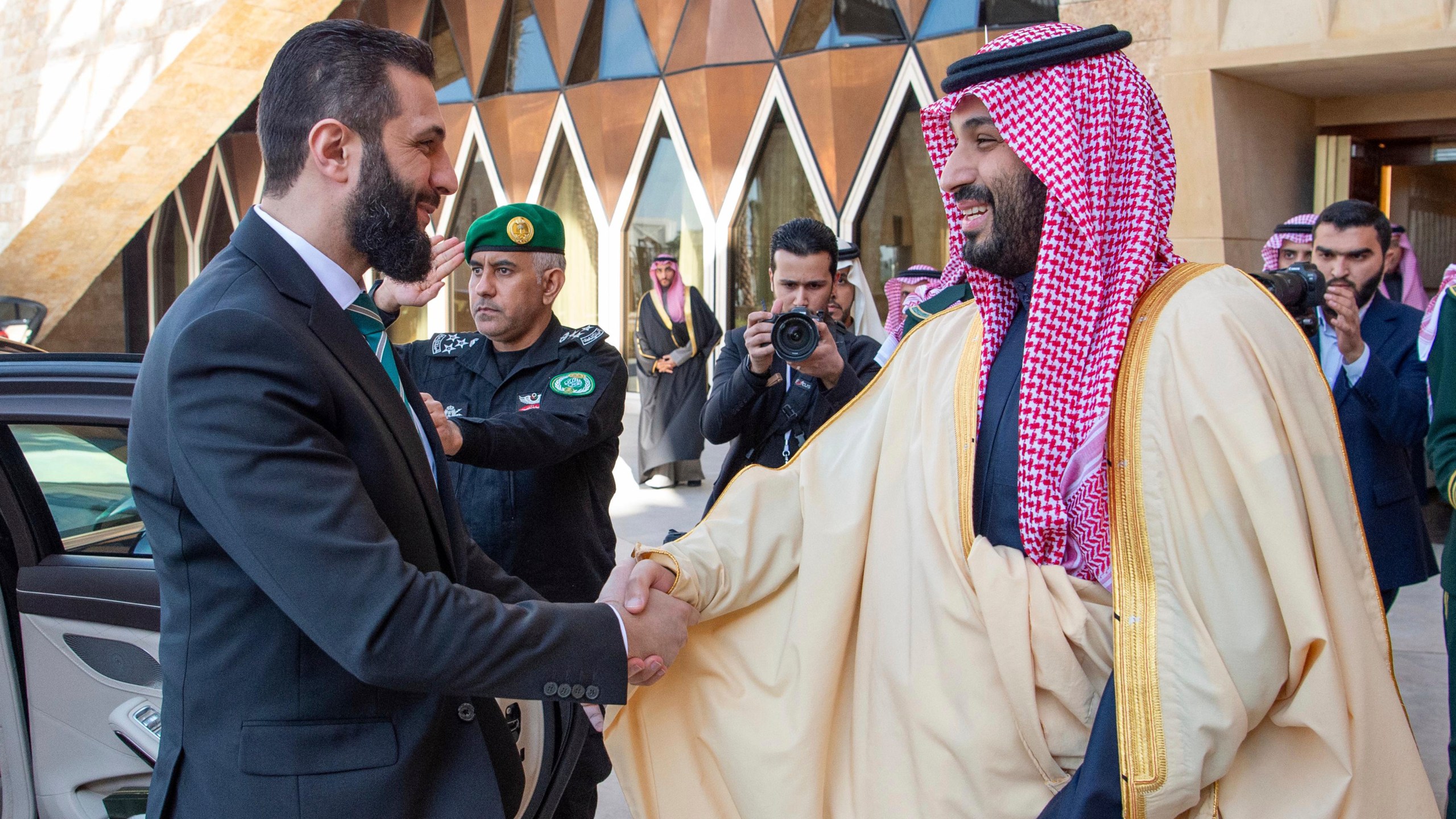 In this photo provided by the Saudi Ministry of Media, Saudi Crown Prince Mohammed bin Salman greets Syria's interim President Ahmad al-Sharaa, left, during his arrival at the royal palace in Riyadh, Saudi Arabia, Sunday, Feb. 2, 2025. (Saudi Ministry of Media via AP)