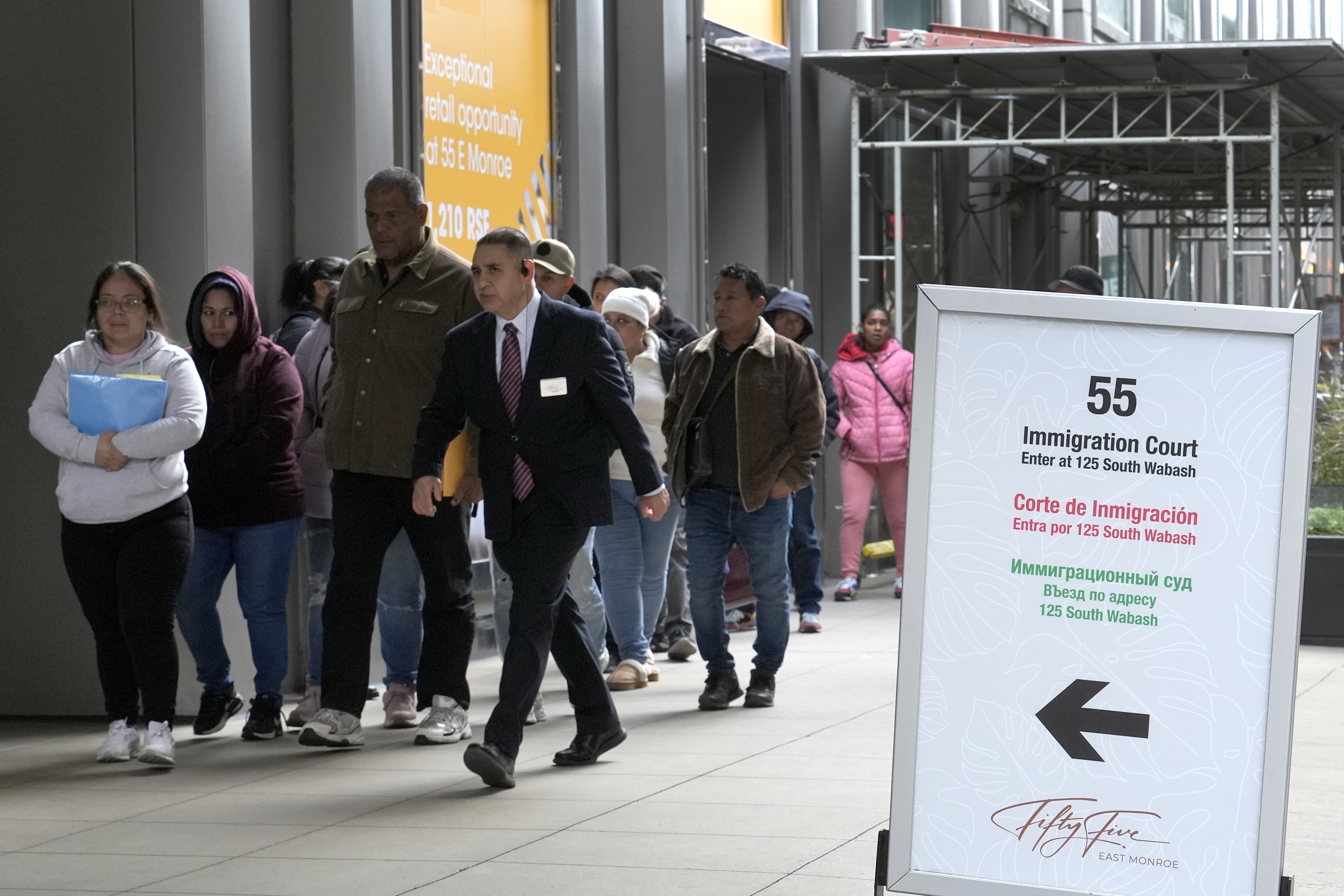 FILE - After waiting in a cue, people are led into a downtown Chicago building where an immigration court presides Tuesday, Nov. 12, 2024, in Chicago. (AP Photo/Charles Rex Arbogast, File)