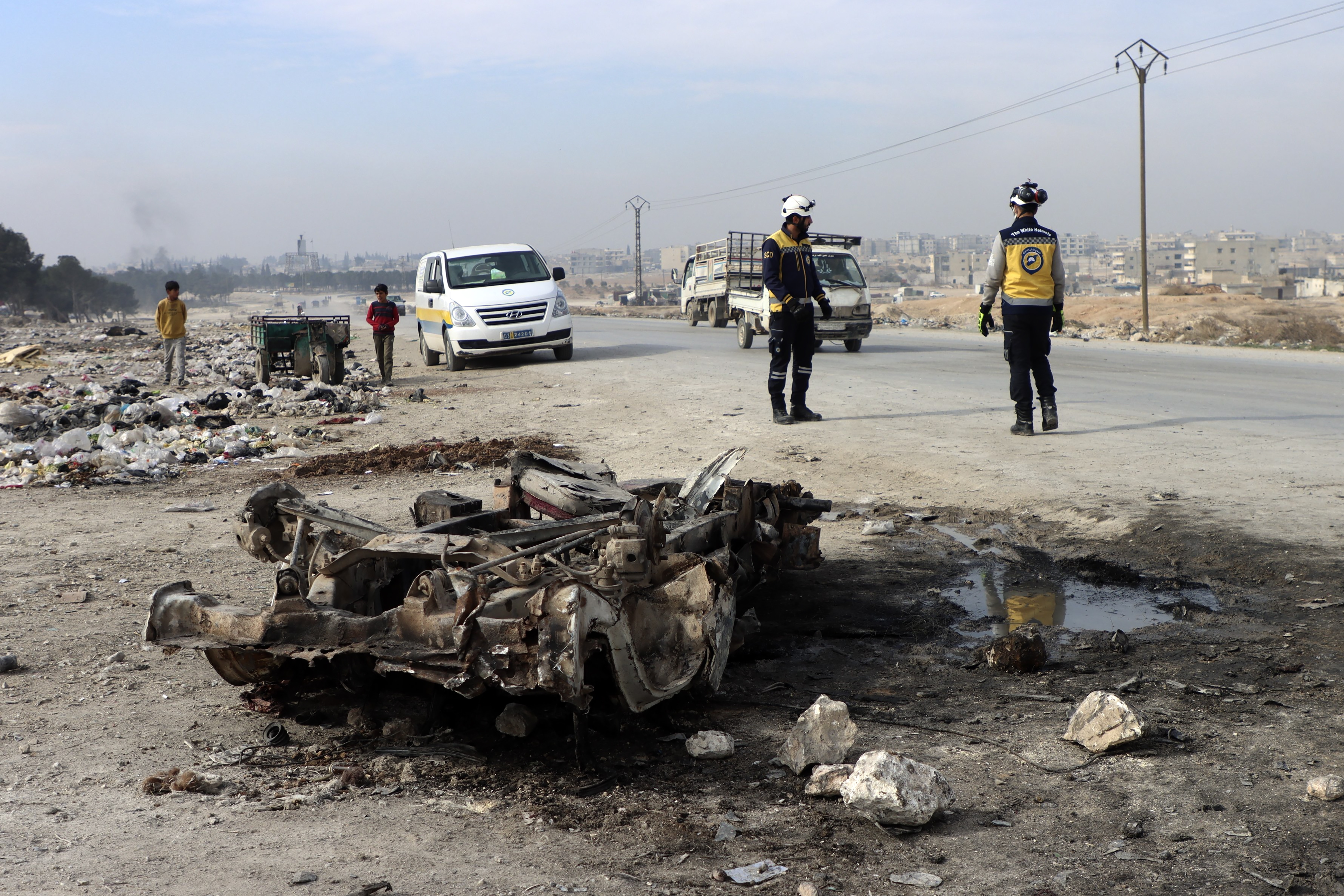 In this photo provided by the Syrian Civil Defense White Helmets, which has been authenticated based on its contents and other AP reporting, Syrian White Helmet civil defense workers inspect the area of a car bomb attack that killed least 15 people and wounded dozens, the local Syrian civil defense reported, on the outskirts of the city of Manbij, Syria, Monday. Feb. 3, 2025. (Syrian Civil Defense White Helmets via AP)