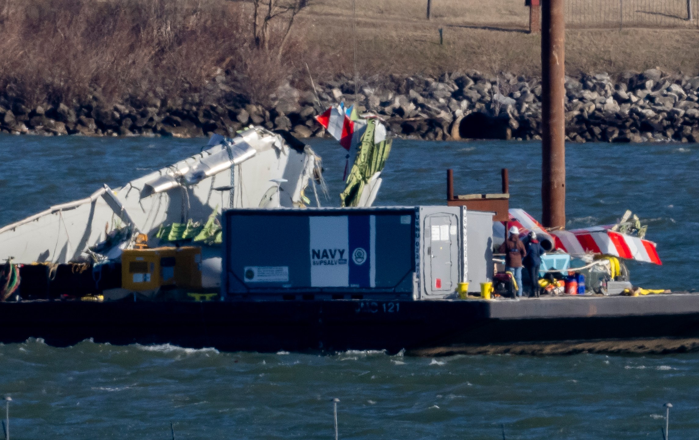 A piece of wreckage is lifted from the water onto a salvage vessel, near the site in the Potomac River of a mid-air collision between an American Airlines jet and a Black Hawk helicopter, at Ronald Reagan Washington National Airport, Tuesday, Feb. 4, 2025, in Arlington, Va. (AP Photo/Ben Curtis)