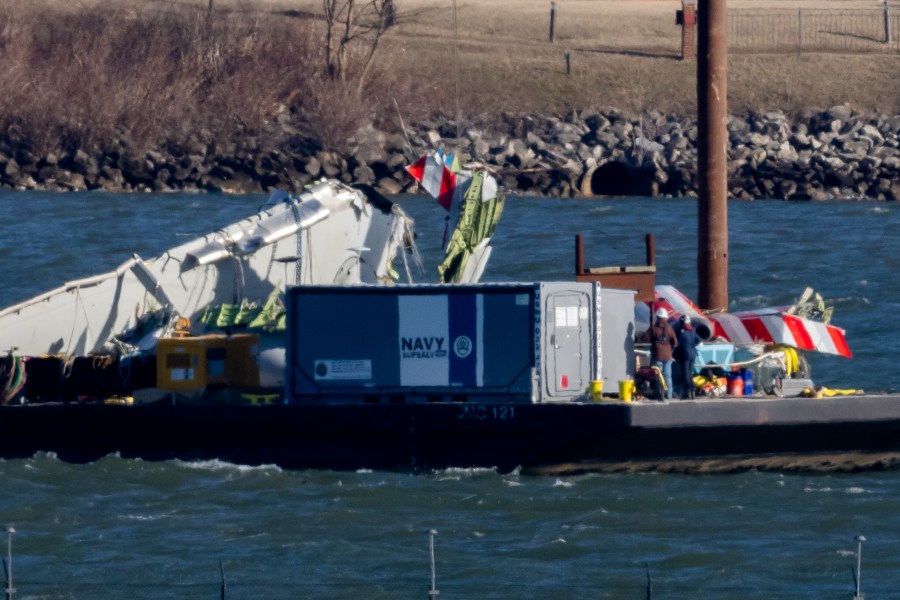 A piece of wreckage is lifted from the water onto a salvage vessel, near the site in the Potomac River of a mid-air collision between an American Airlines jet and a Black Hawk helicopter, at Ronald Reagan Washington National Airport, Tuesday, Feb. 4, 2025, in Arlington, Va. (AP Photo/Ben Curtis)