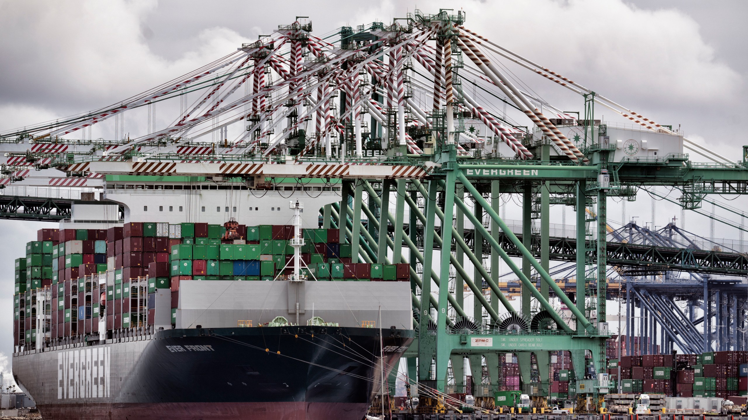 FILE - A sailboat passes a cargo ship unloading containers the port of Los Angeles in San Pedro on Thursday, June 15, 2023. (AP Photo/Richard Vogel, File)