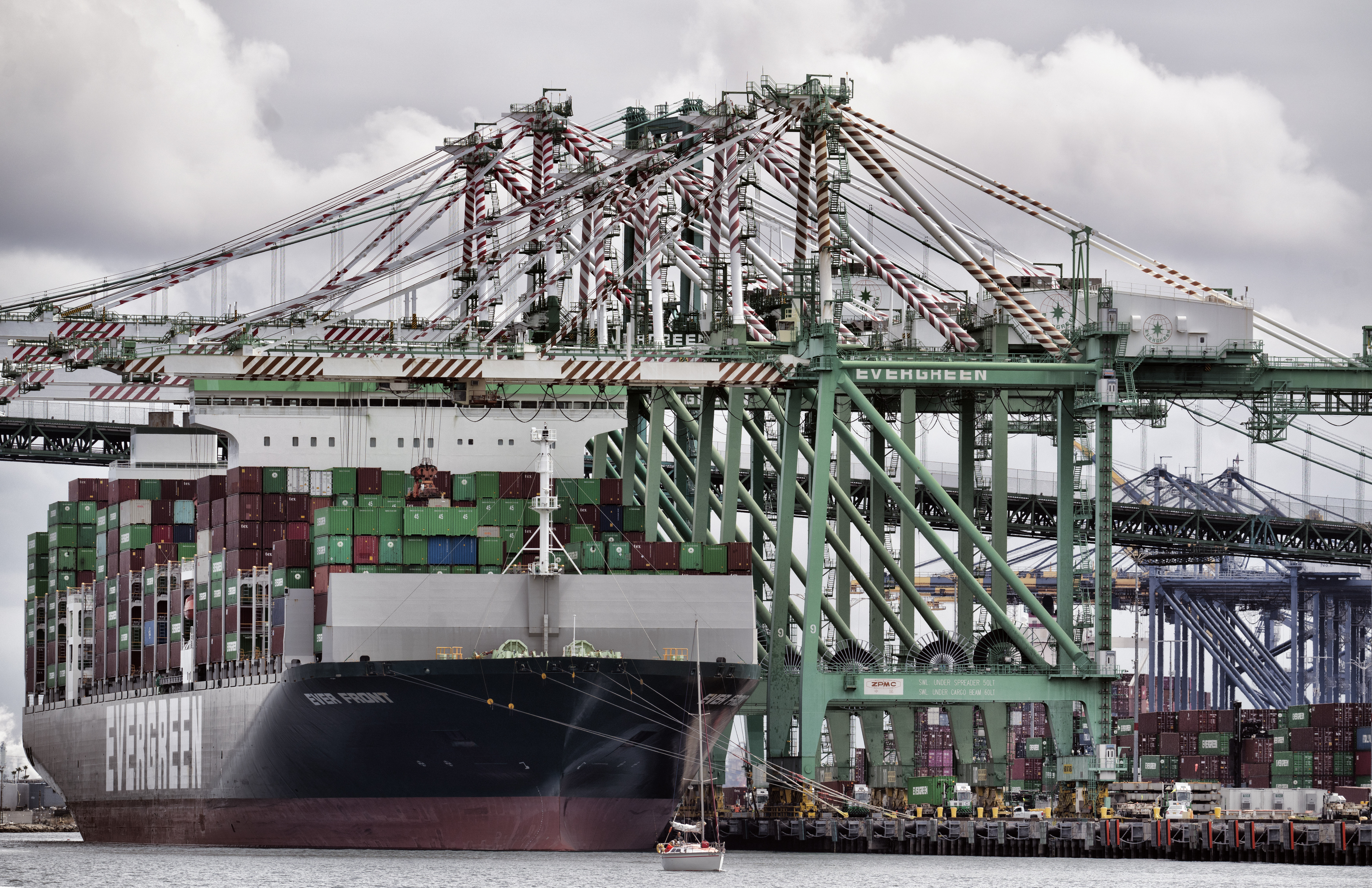 FILE - A sailboat passes a cargo ship unloading containers the port of Los Angeles in San Pedro on Thursday, June 15, 2023. (AP Photo/Richard Vogel, File)