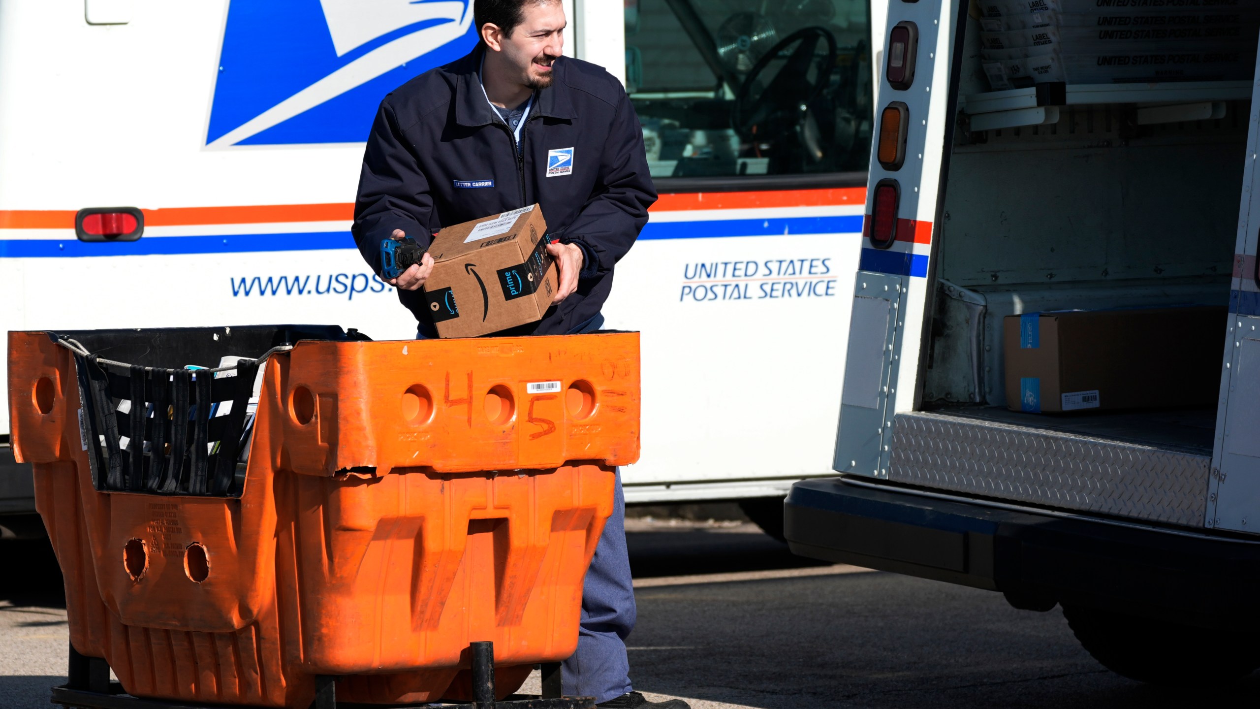 FILE - A U.S. Postal Service employee loads parcels outside a post office in Wheeling, Ill., on Jan. 29, 2024. (AP Photo/Nam Y. Huh, File)