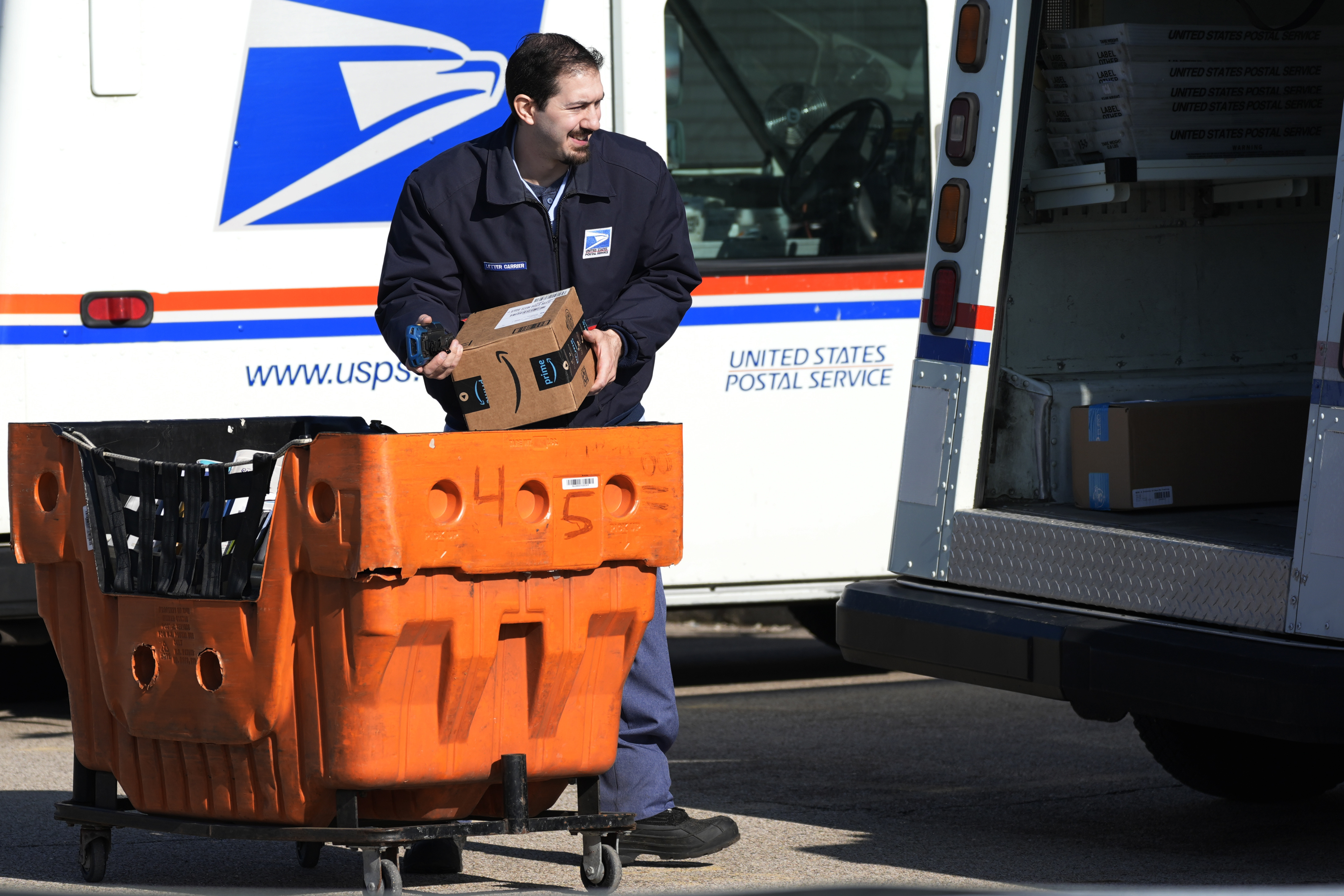 FILE - A U.S. Postal Service employee loads parcels outside a post office in Wheeling, Ill., on Jan. 29, 2024. (AP Photo/Nam Y. Huh, File)